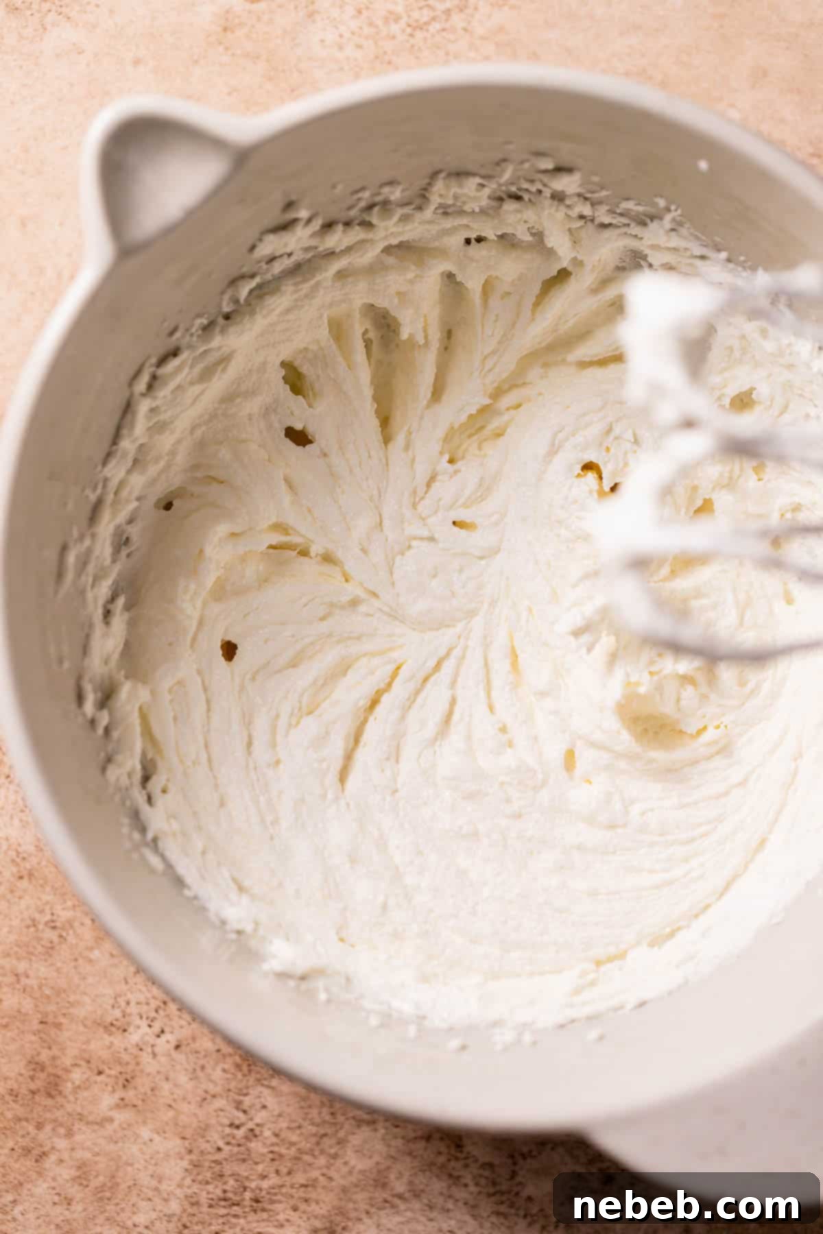 A mixing bowl filled with creamed butter, sugar, and oil, showing a light and fluffy texture, indicating proper creaming.