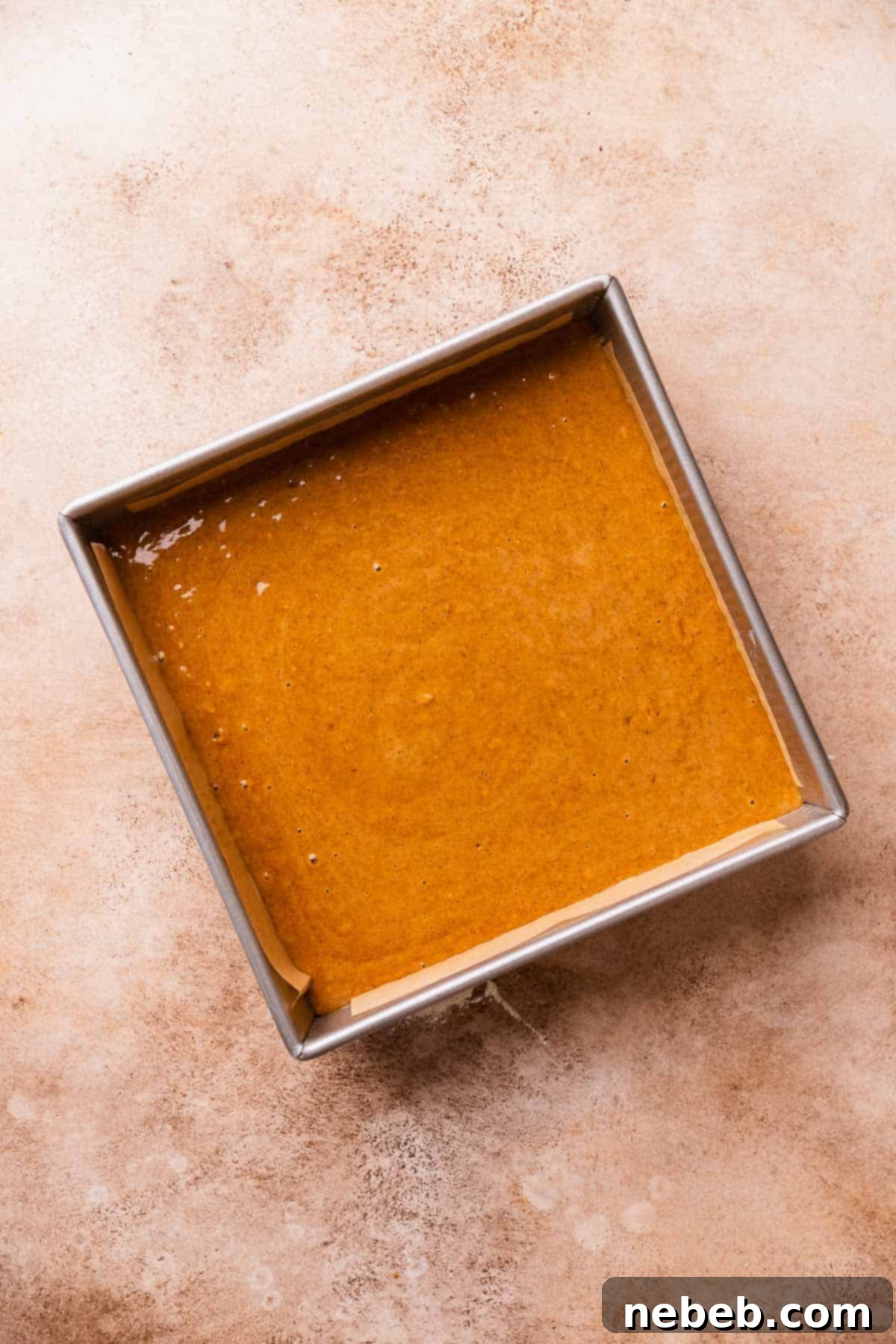 A baking pan full of the gingerbread cake batter before baking.