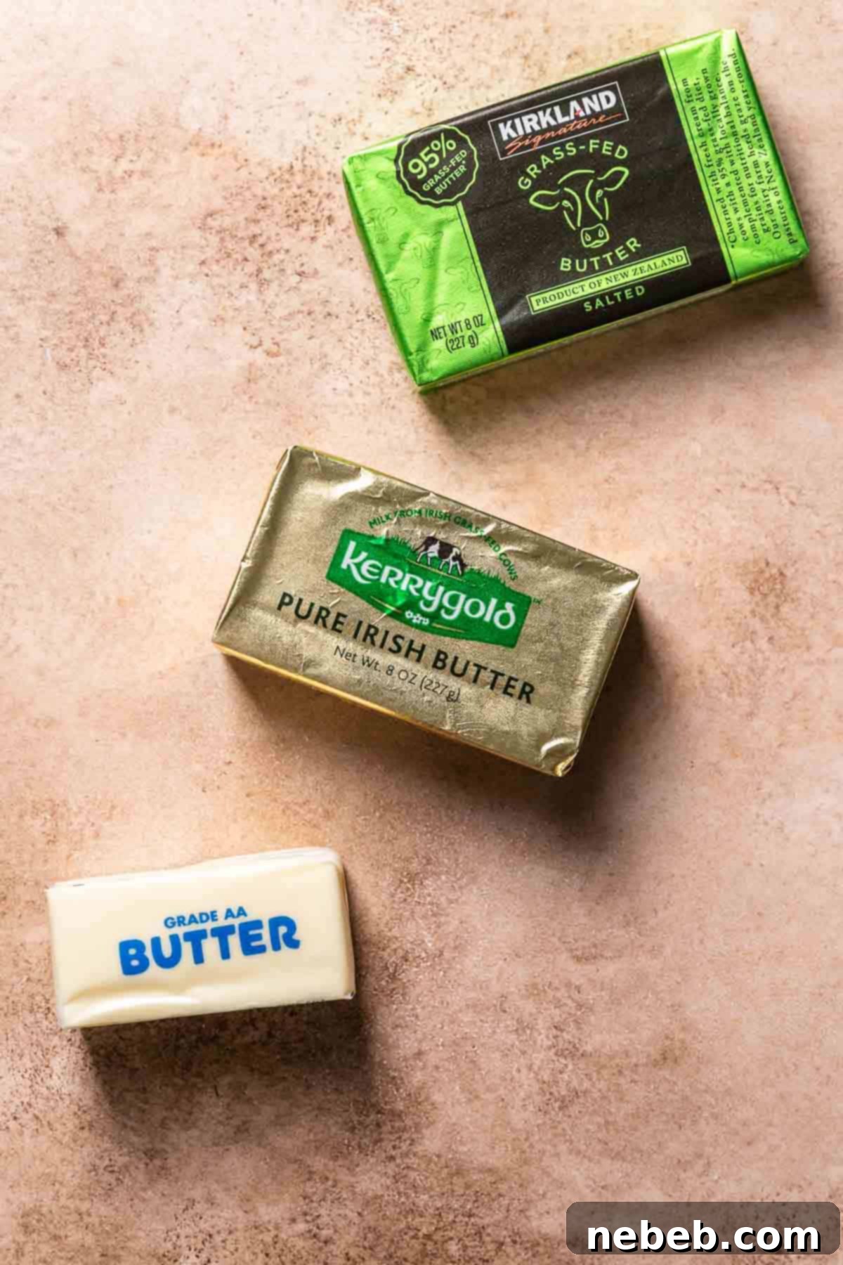Sticks of butter neatly arranged on a rustic brown backdrop, symbolizing quality and choice.