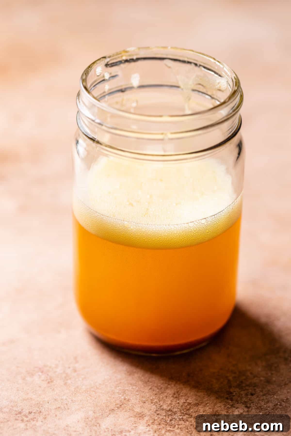 A glass mason jar filled with freshly browned butter, ready for use.
