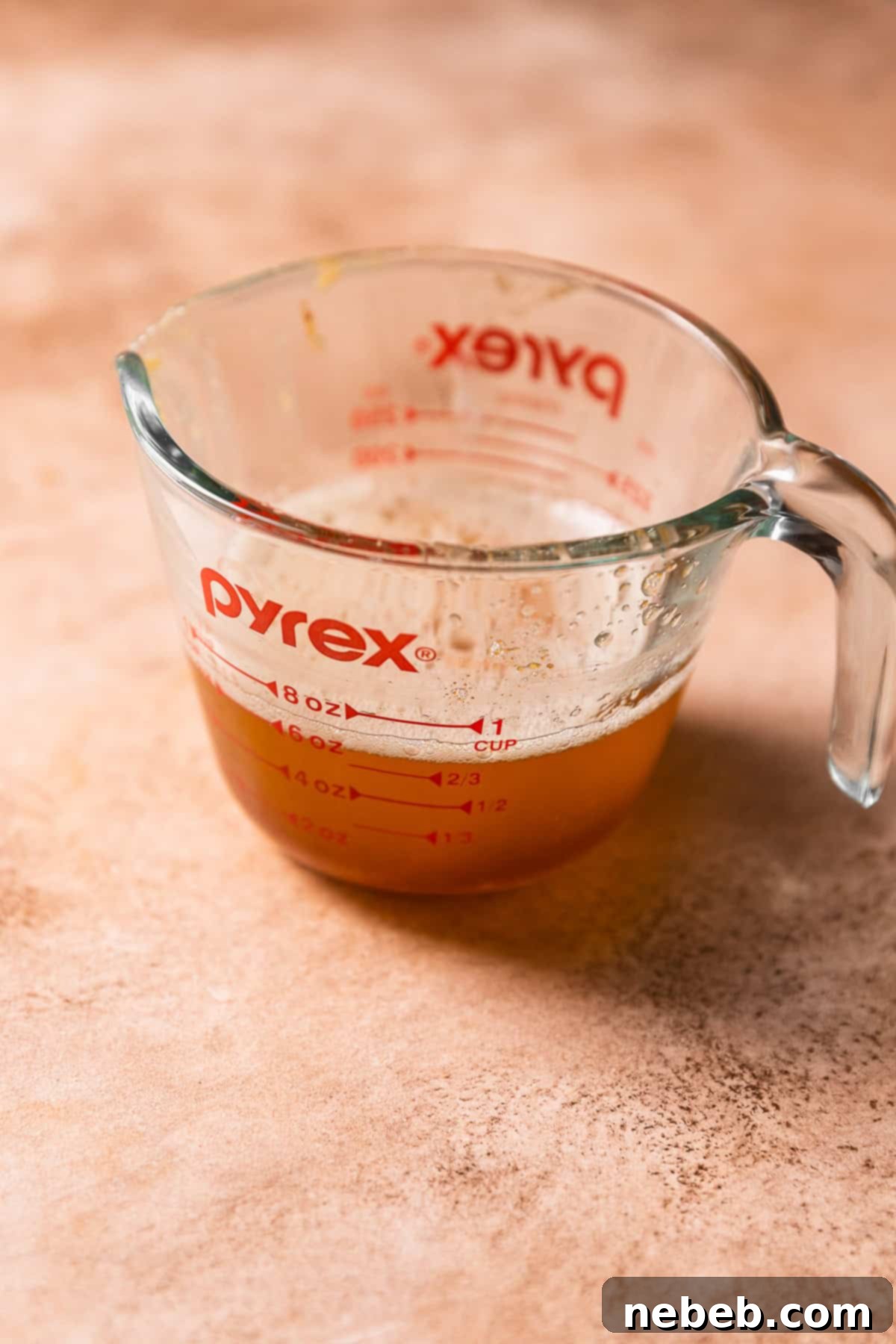 A glass measuring cup with liquid brown butter.