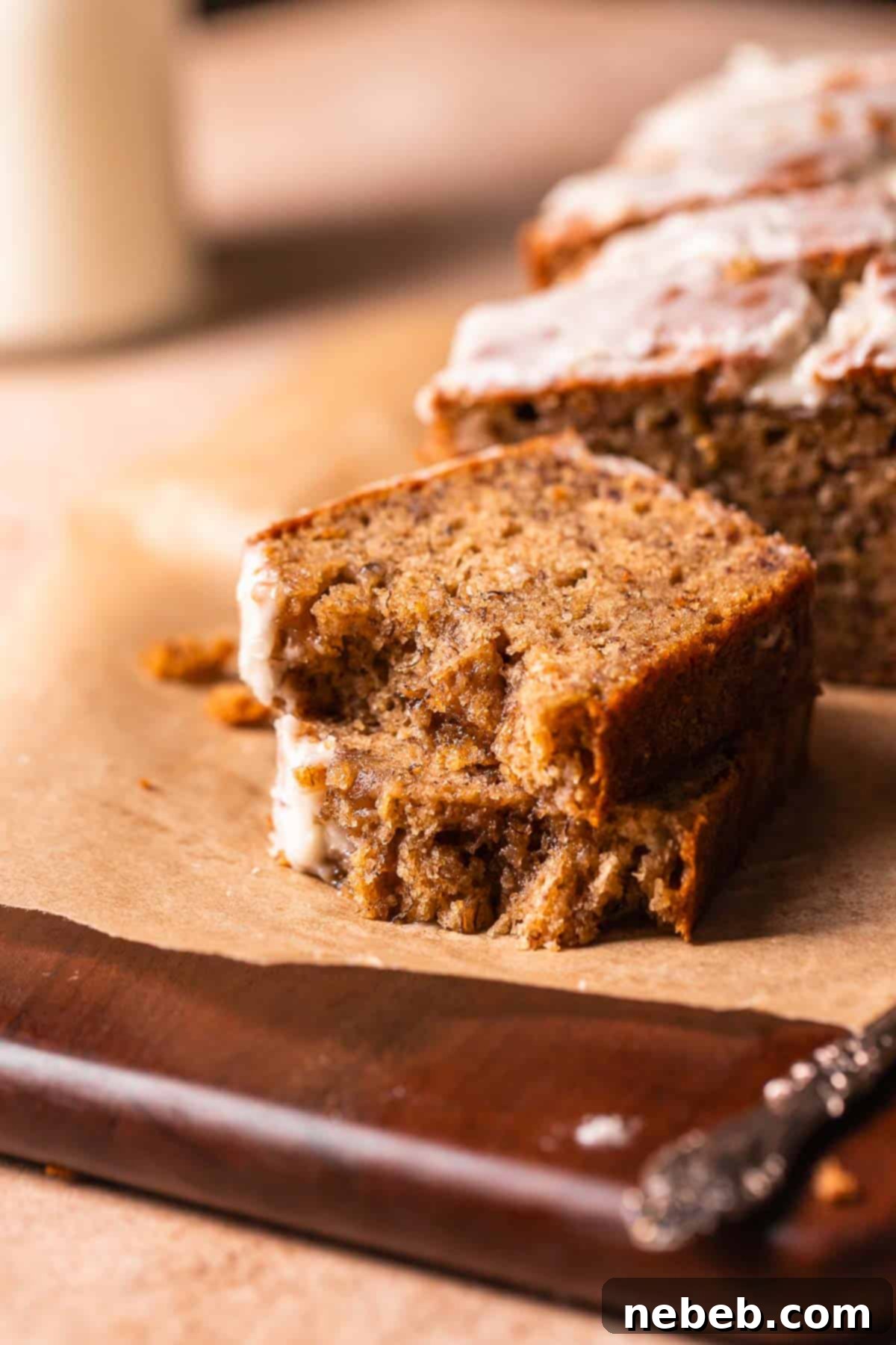 A slice of banana bread broken in half to show the moist and tender texture.