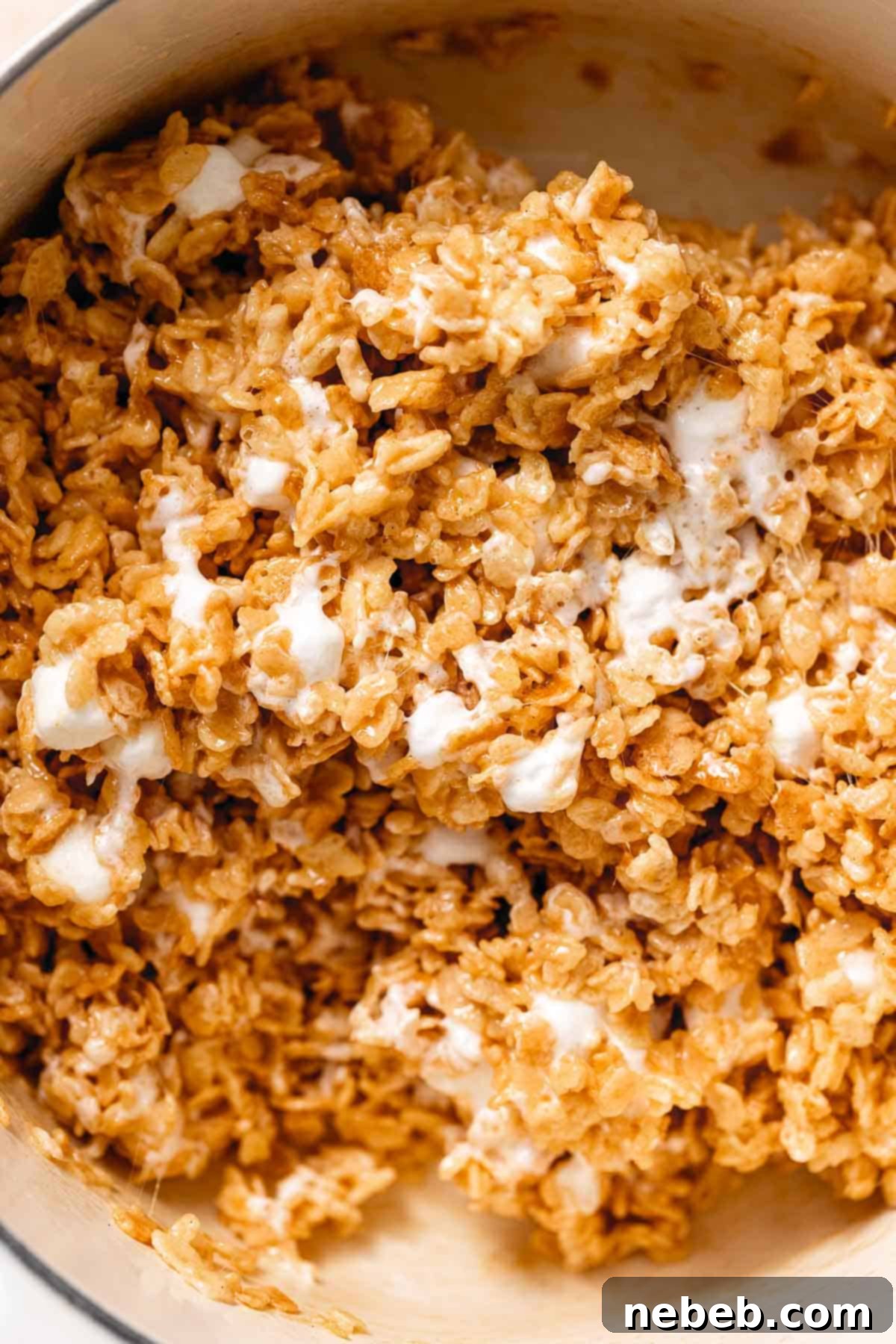 An up close shot of the rice krispie mixture after adding in the extra marshmallows to show their gooey texture.