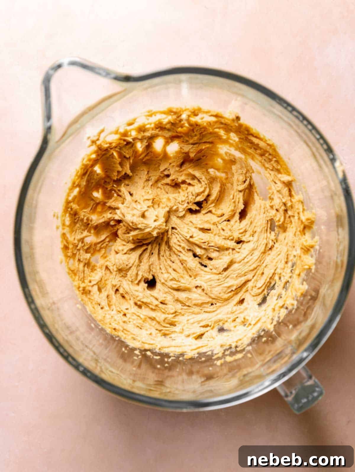 A glass mixing bowl with the creamed butter and sugar.