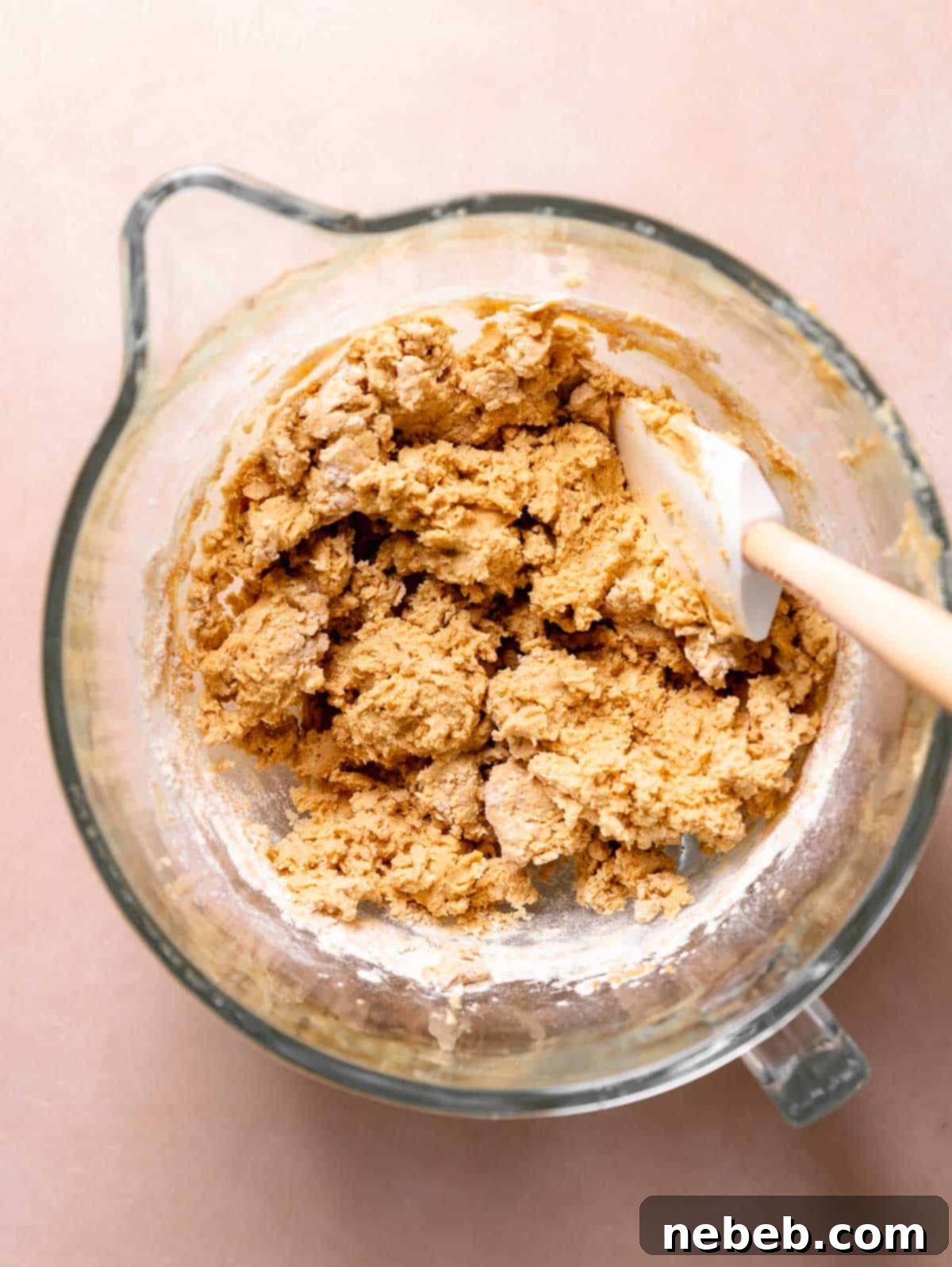 A glass mixing bowl with the cookie dough after folding in the dry ingredients.