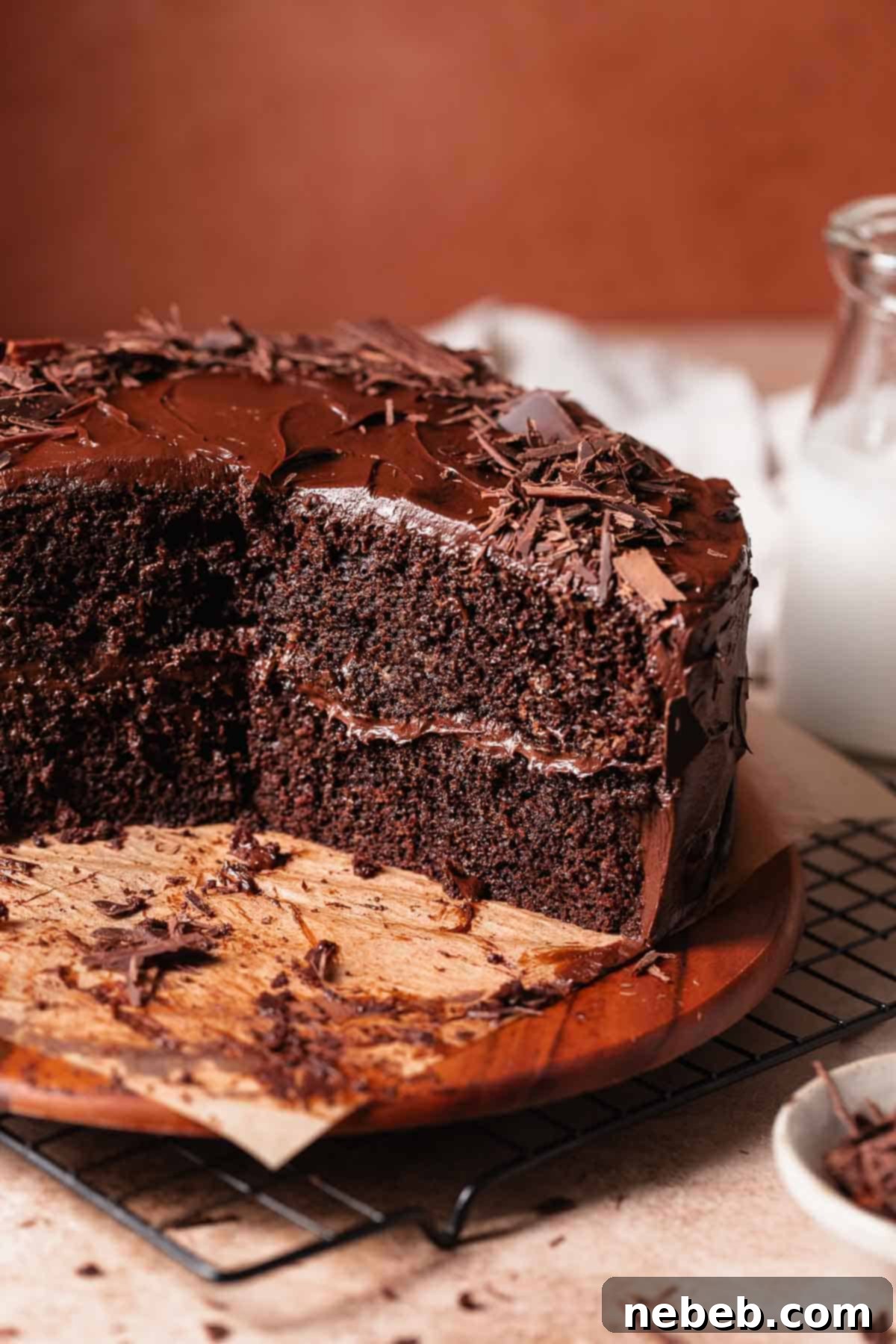 Dark chocolate cake on a wooden board cut in half to show the super moist texture.
