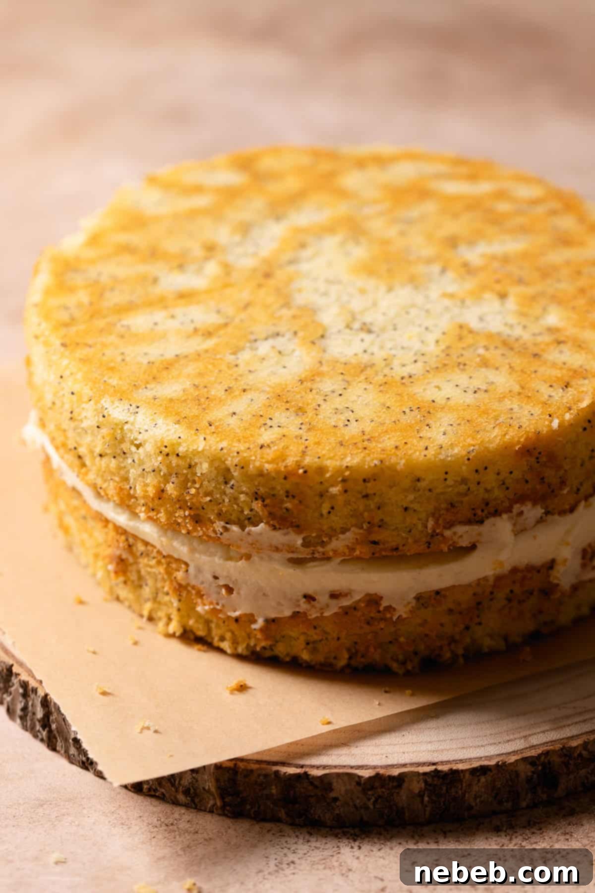 Lemon poppy cake with lemon curd center on a wooden platter with no frosting.