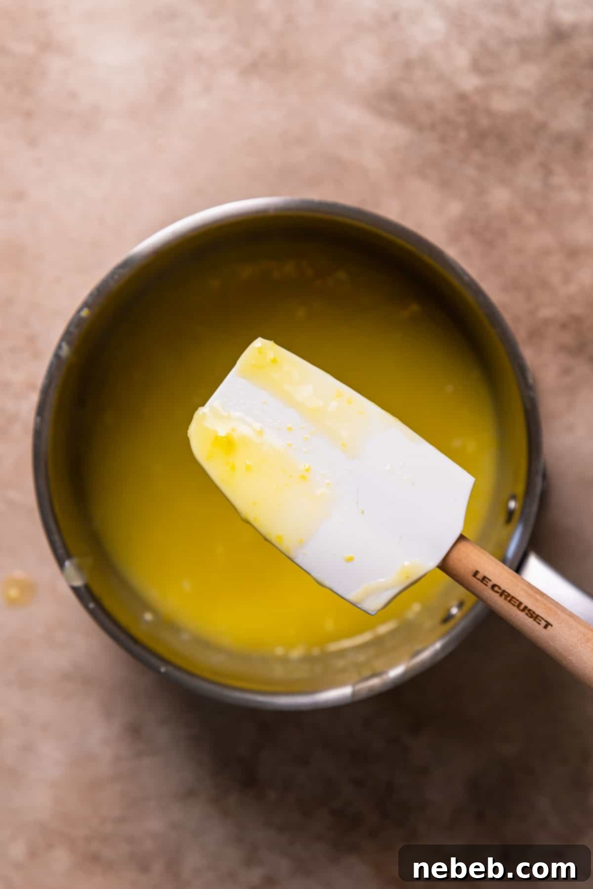 A spatula coated in thickened lemon curd, demonstrating the perfect consistency when it's ready.
