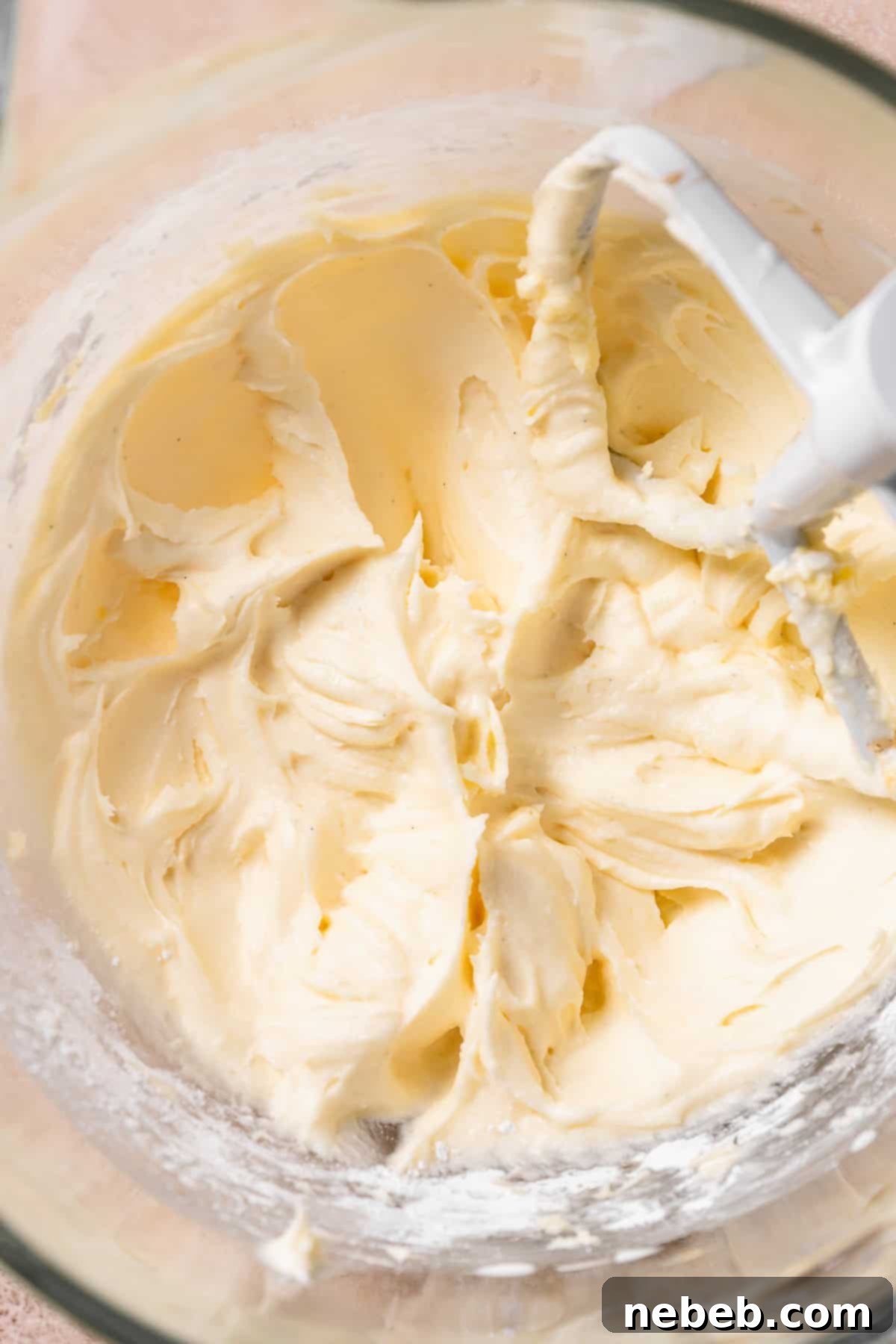 Fluffy cream cheese frosting in a mixing bowl, ready to be spread.