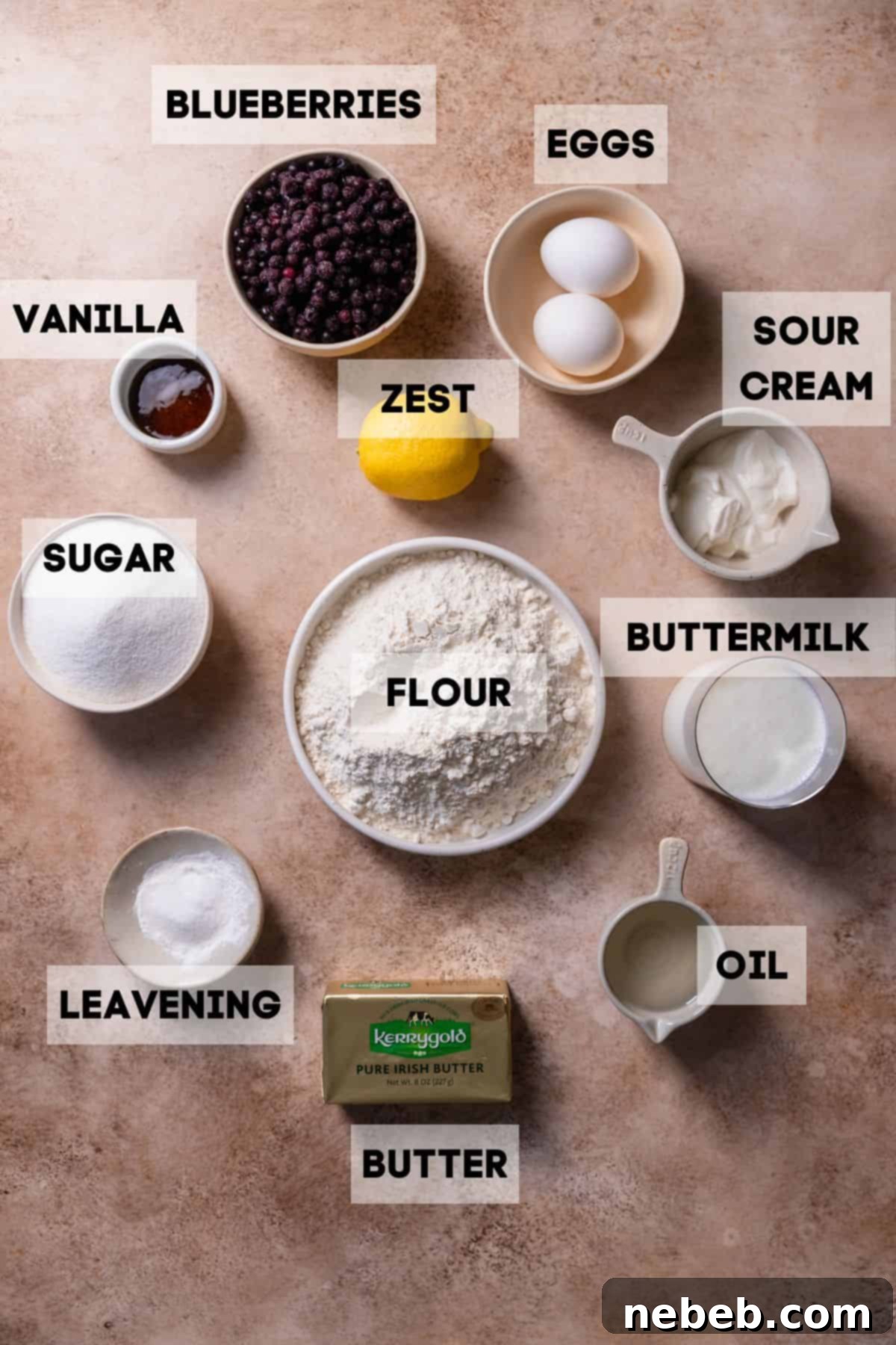 Ingredients to make moist blueberry muffins laid out in bowls with labels, ready for baking.