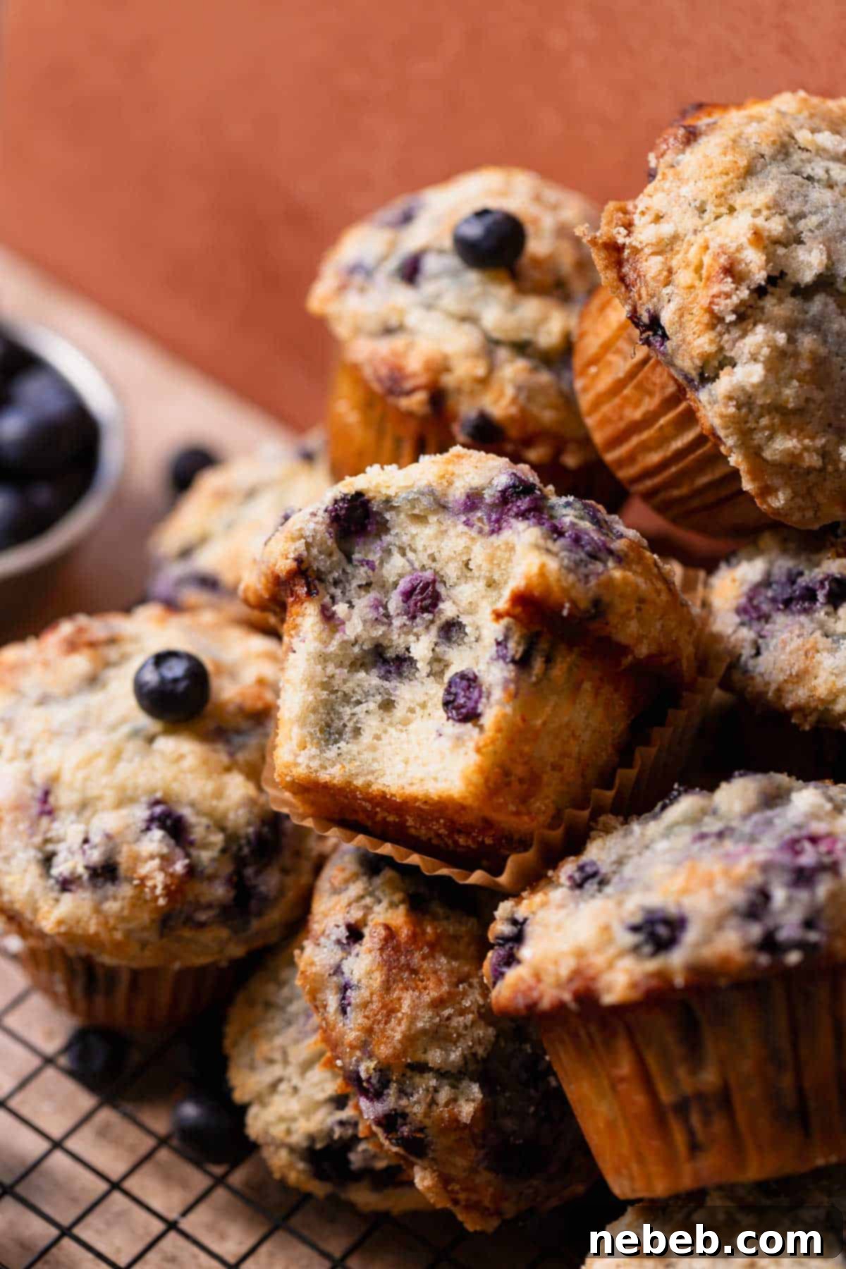 A blueberry muffin with a bite taken out of it, revealing the moist and fluffy interior packed with blueberries.