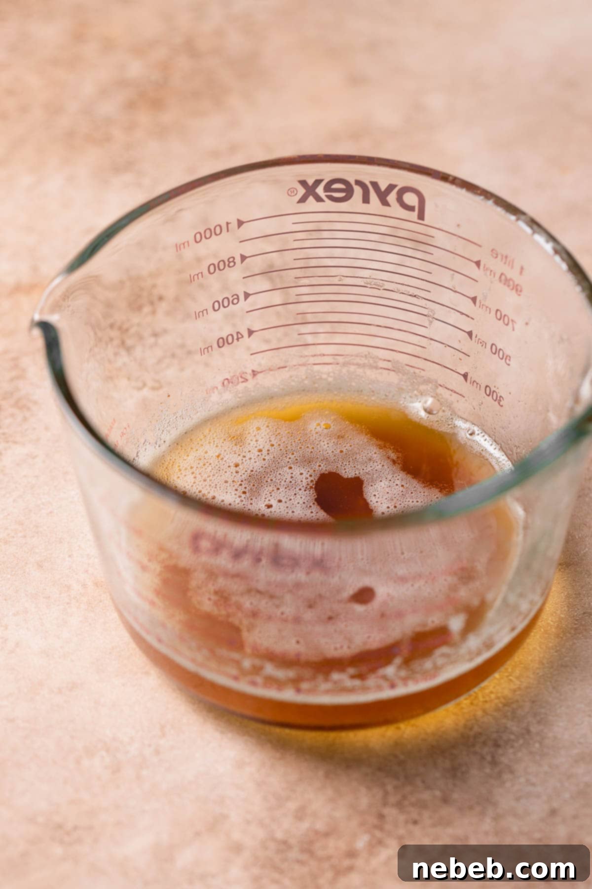 A glass bowl of rich, amber-colored browned butter, ready for the next step in making lemon brownies.