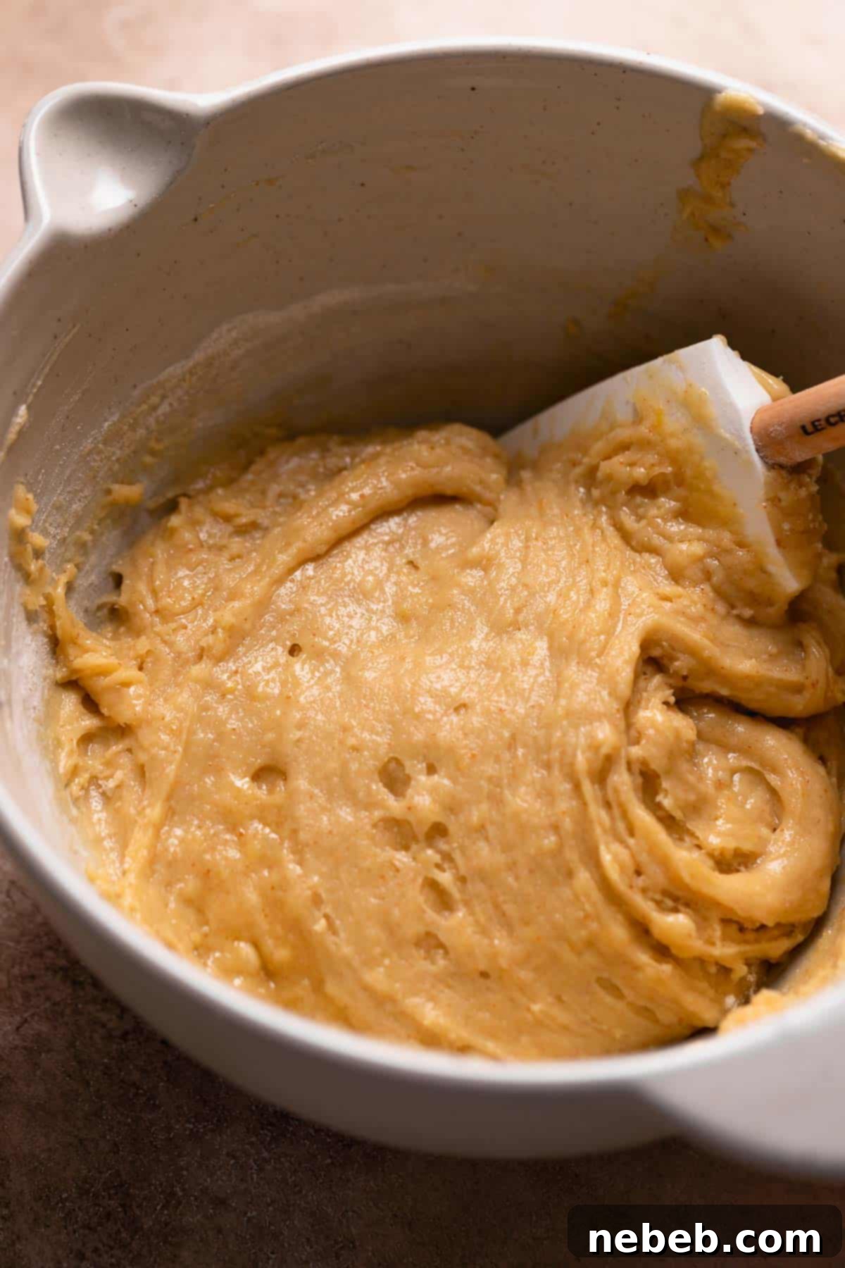 A mixing bowl filled with smooth, vibrant lemon brownie batter, ready for baking.