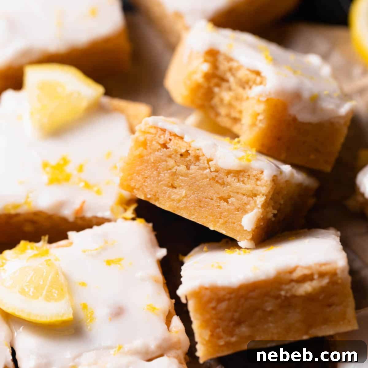 Fudgy lemon brownies with lemon icing and lemon zest on top, beautifully presented.