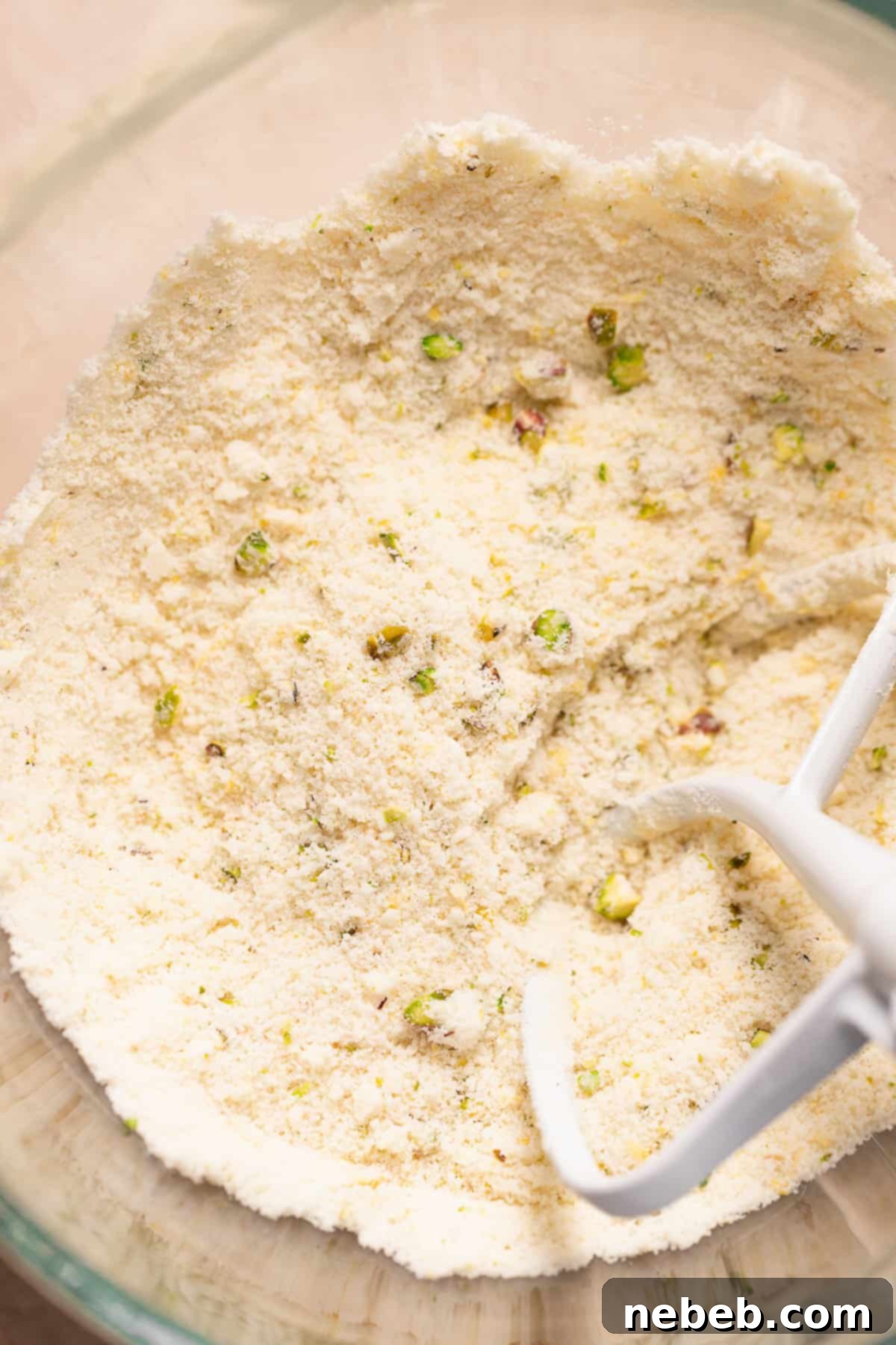 Mixing bowl with dry ingredients and butter combined, showing a coarse, sandy texture for cupcake batter.