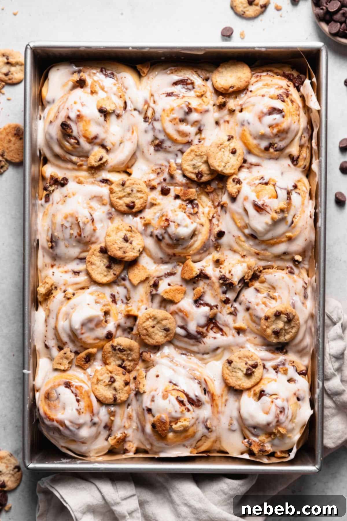 Chocolate chip cookie rolls with vanilla icing and mini cookies on top.