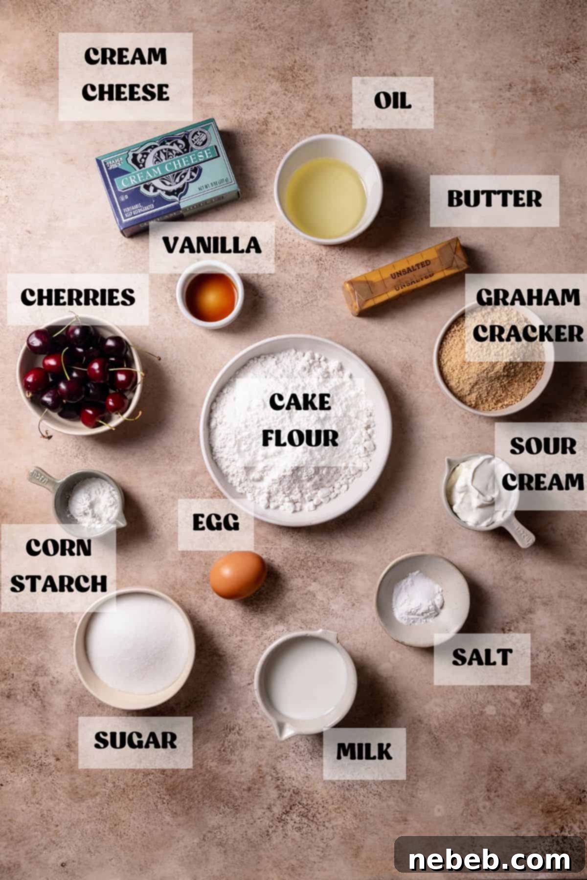 Ingredients needed to make cherry cheesecake cupcakes laid out in bowls with labels, including flour, sugar, cherries, butter, and cream cheese.