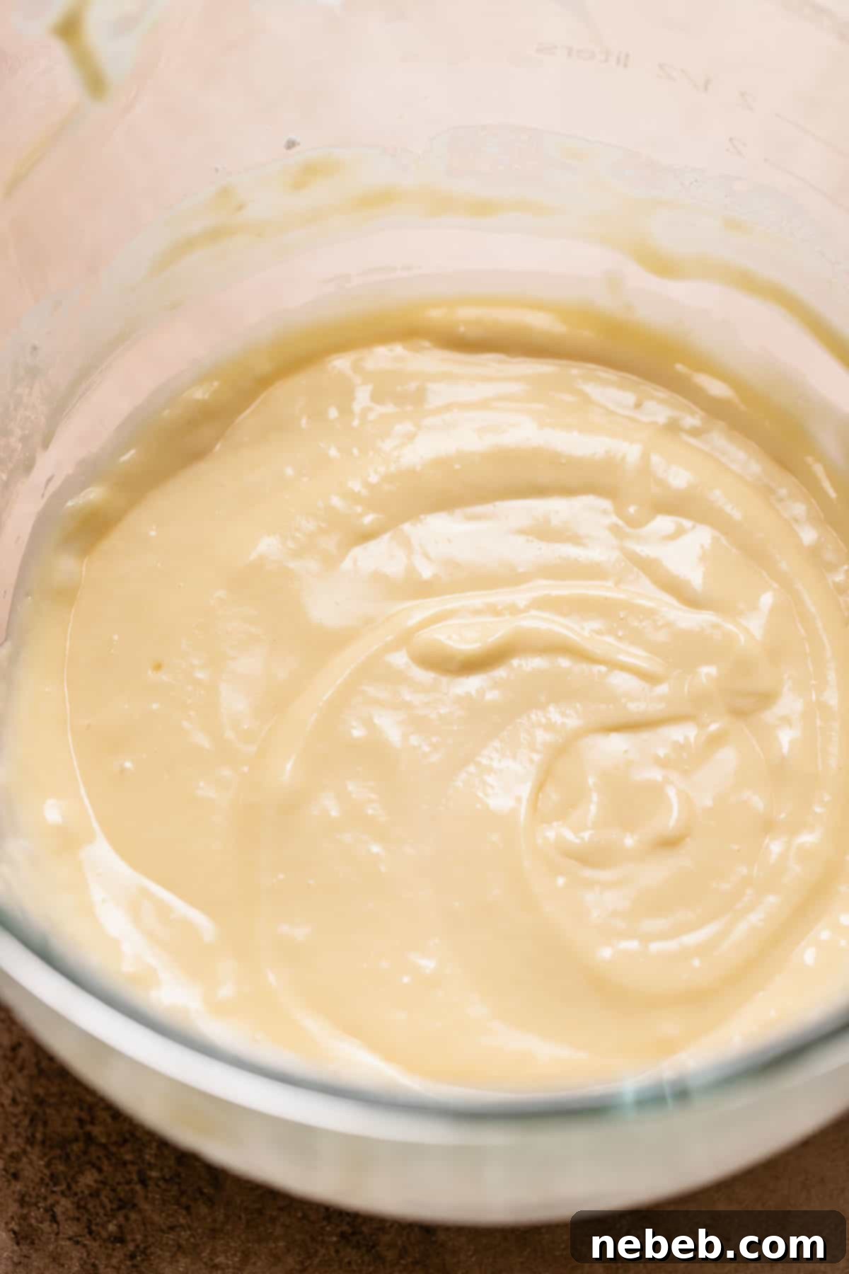 A glass mixing bowl with the flavored cupcake batter, showing its smooth consistency.