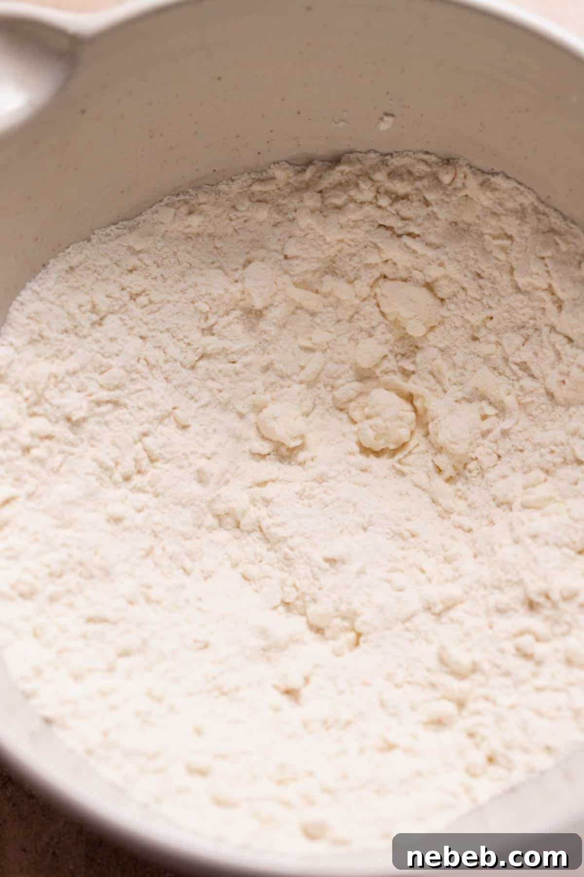 A large bowl with the dry ingredients and pea-sized butter for the scones.