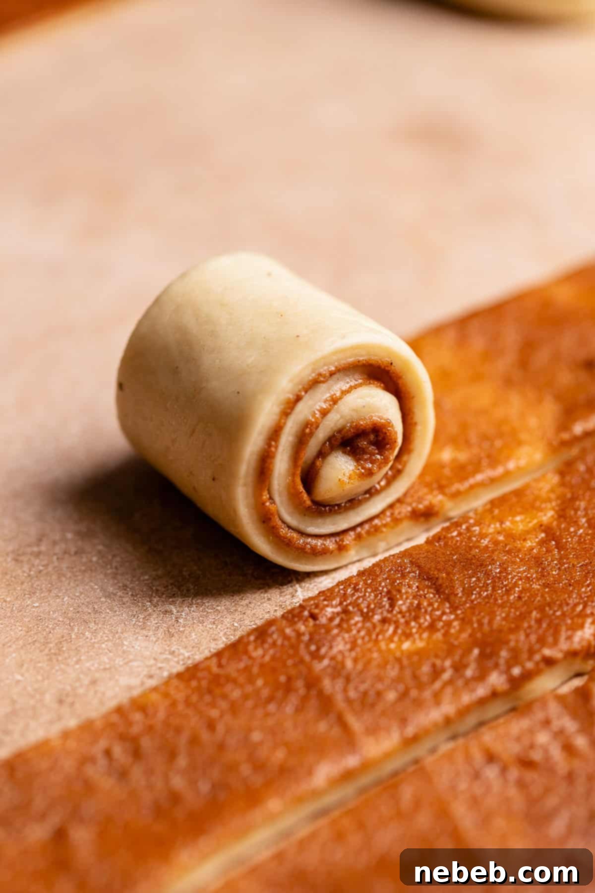 A strip of dough being rolled up.