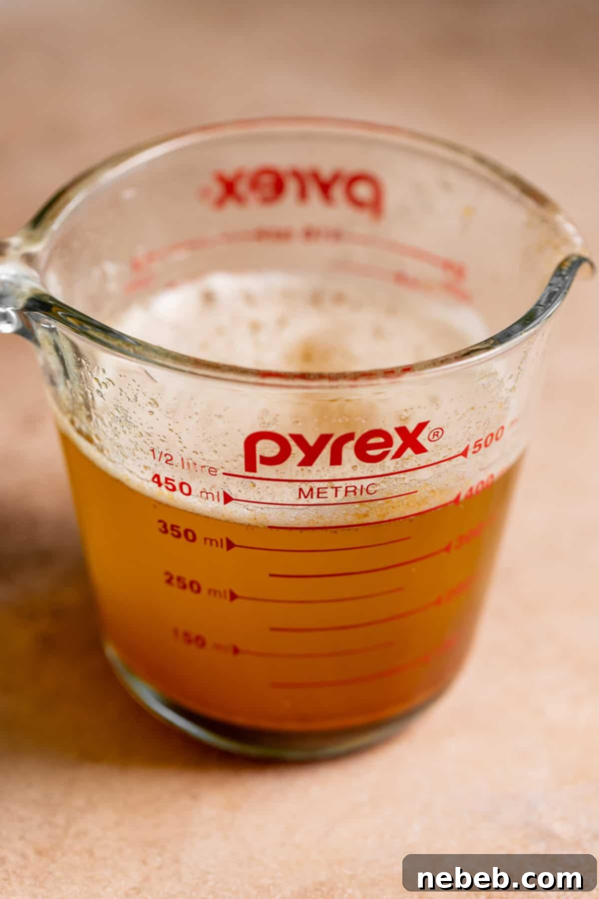 Liquid brown butter in a glass measuring cup.