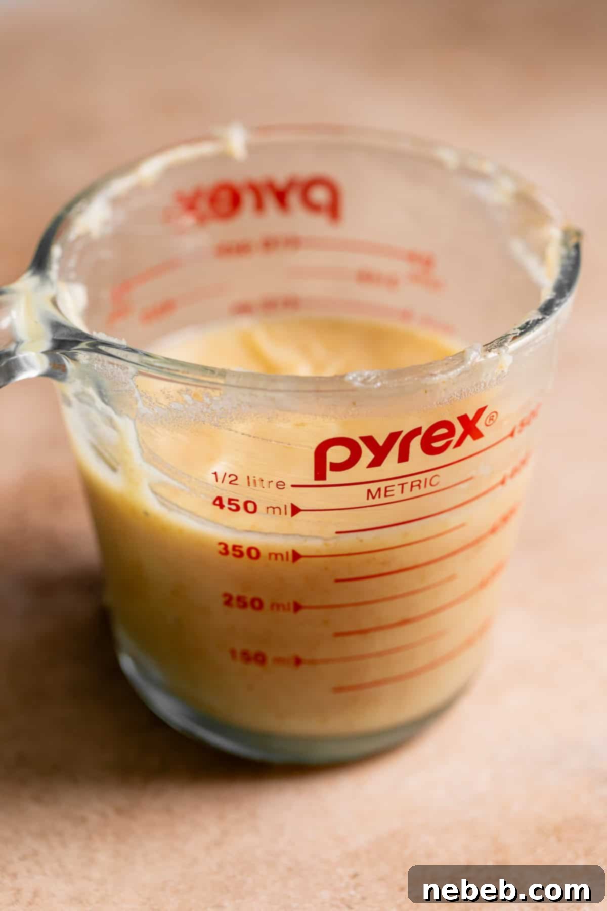 Solidified brown butter in a glass cup.