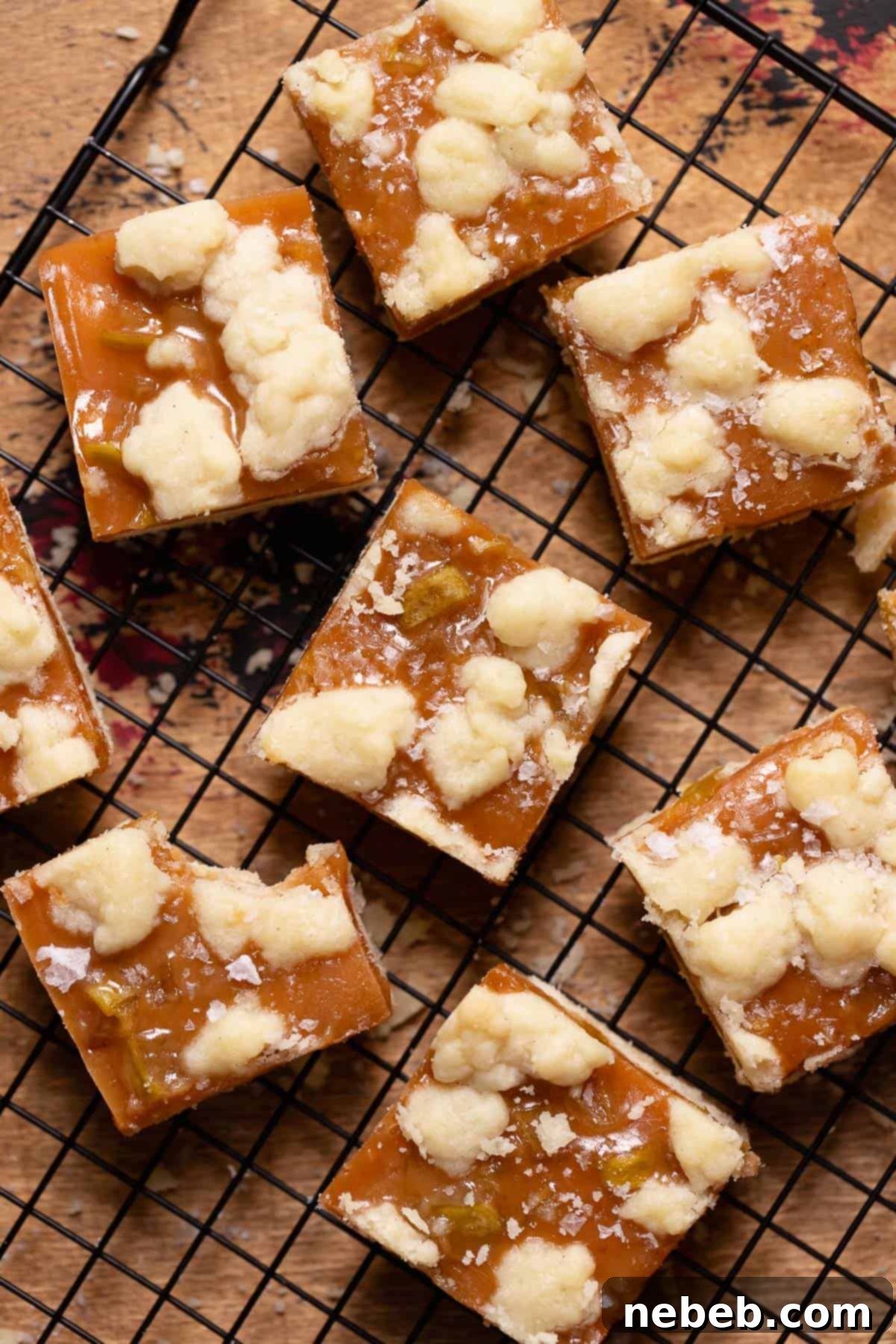 Caramel apple bars on a wire rack, glistening with caramel and a sprinkle of sea salt.