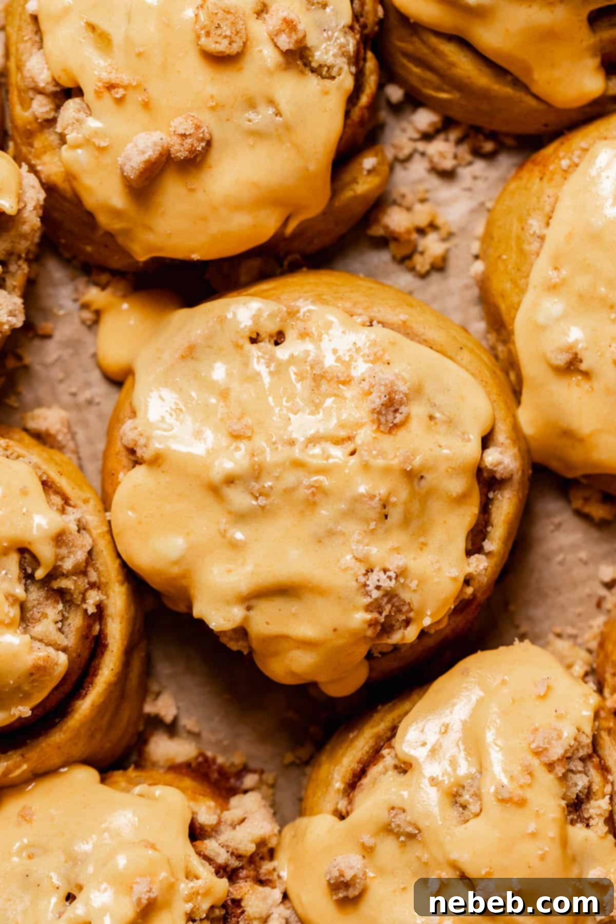Irresistible Pumpkin Cinnamon Rolls generously topped with creamy pumpkin cream cheese frosting, ready to be enjoyed.