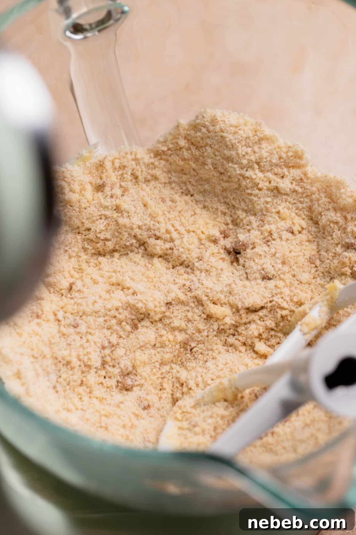 A mixing bowl with the dry ingredients and butter mixed together, forming a breadcrumb-like texture.