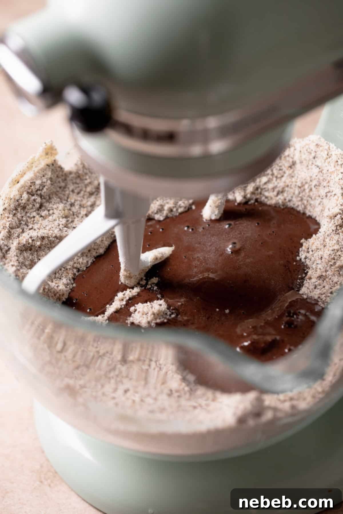 The wet ingredients being mixed into the dry ingredients in a mixing bowl, creating a smooth batter.