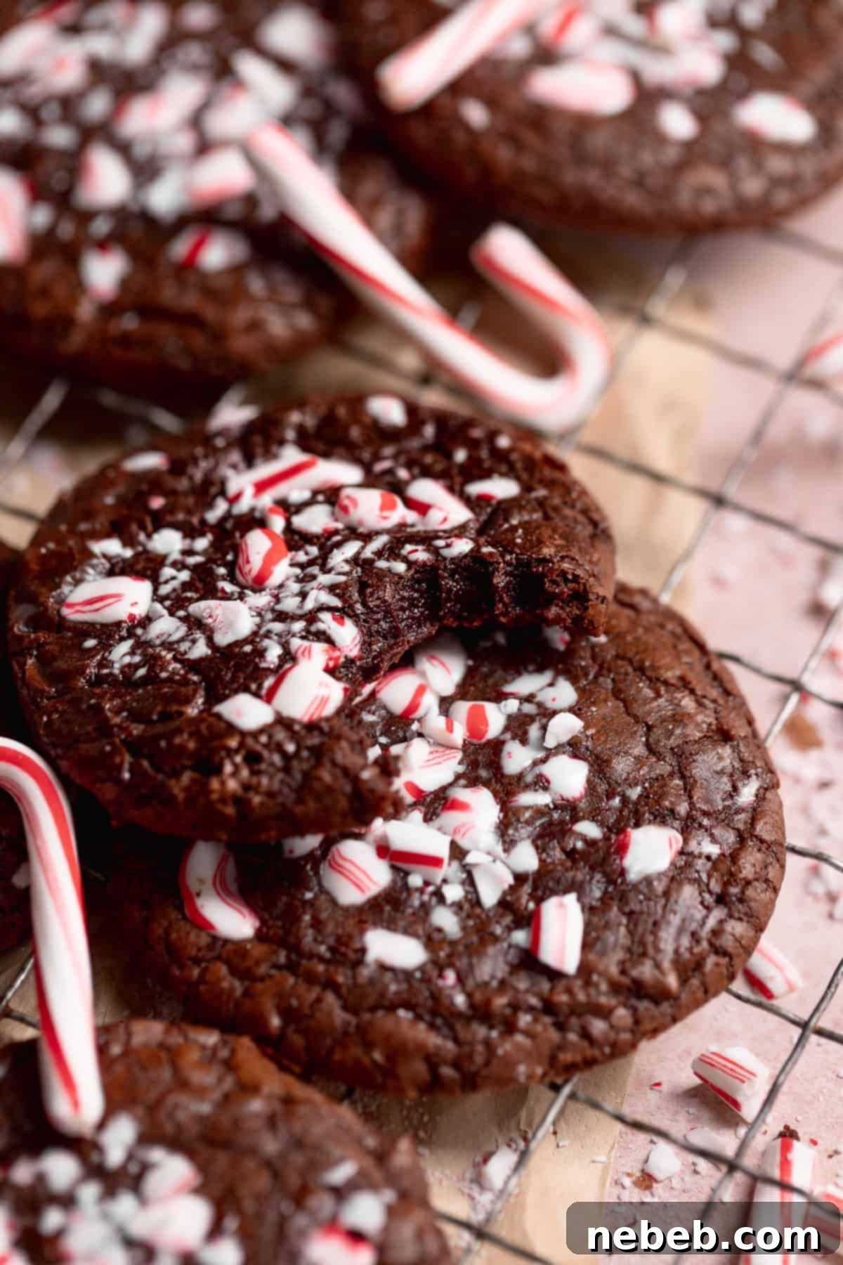Close-up of a double chocolate peppermint cookie with a bite taken out, showing its fudgy interior and crushed peppermint topping, perfect for holiday gatherings.