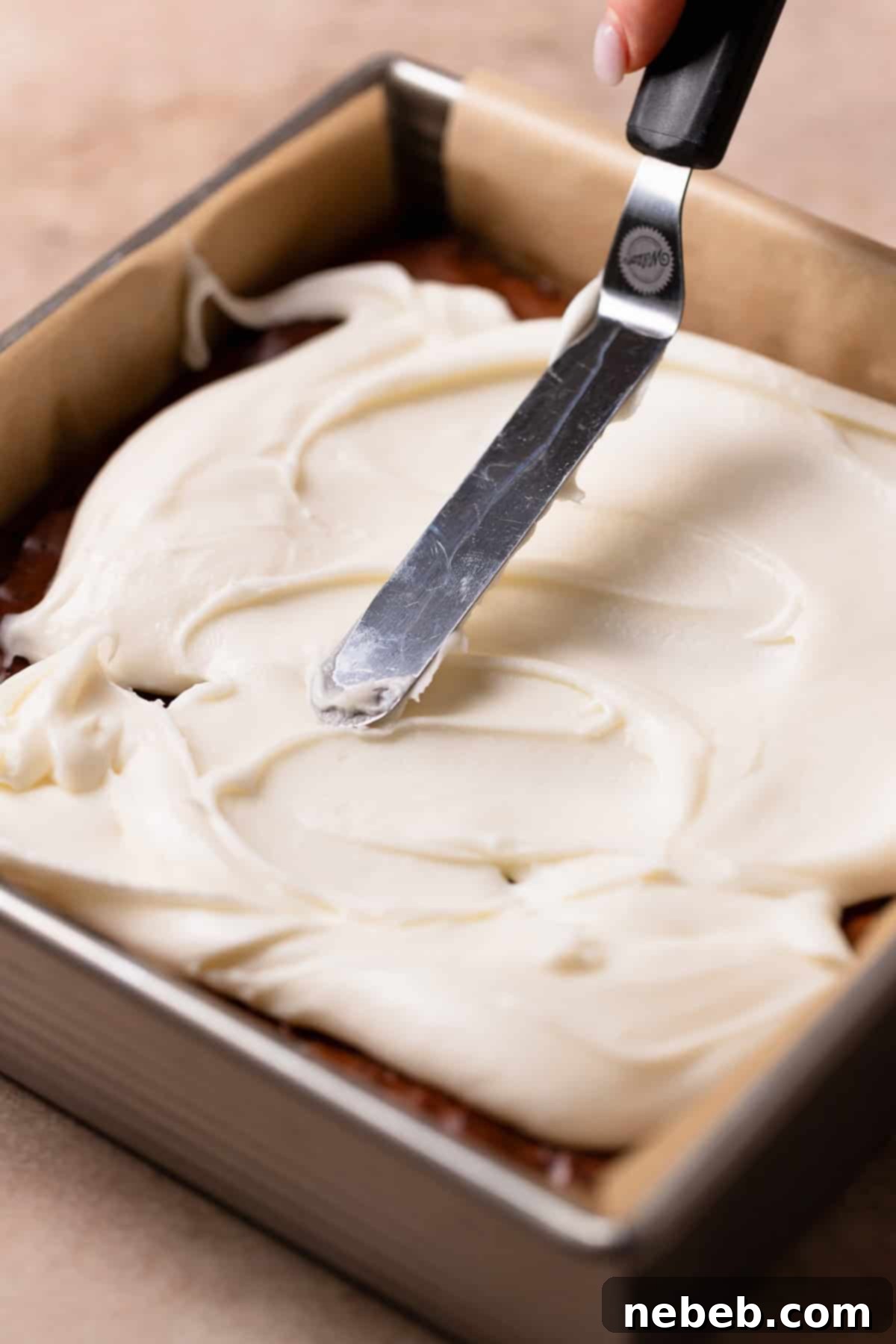 Cool Mint Chocolate Brownies 8 An offset spatula smoothly spreading thick peppermint frosting over a pan of cooled chocolate brownies.