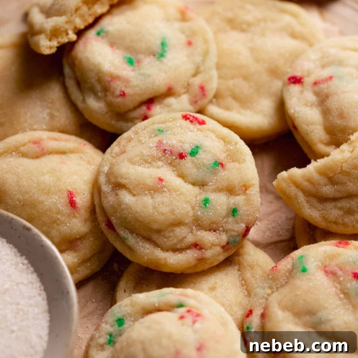 Homemade sugar cookies in a pile on a tray.