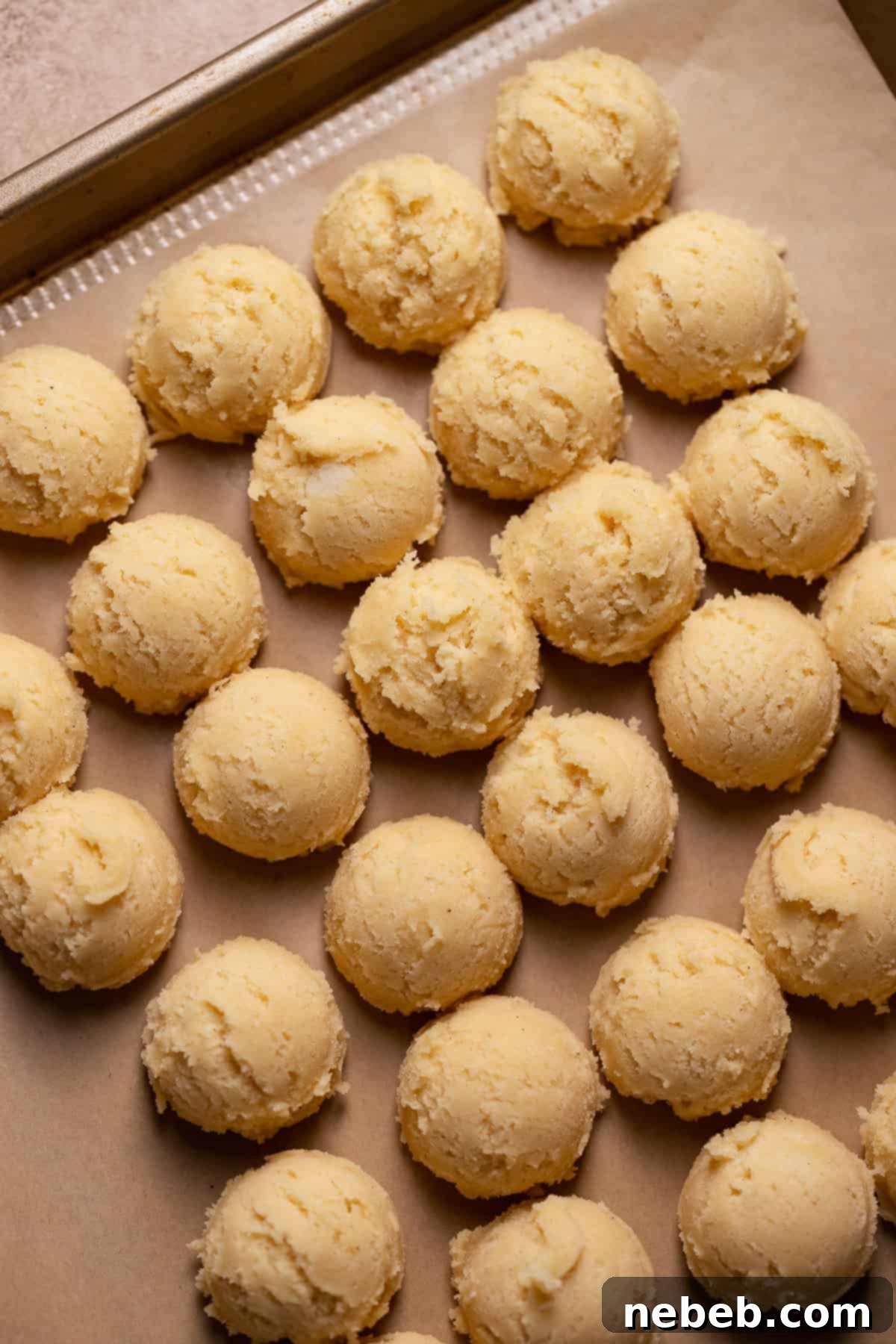 Scooped sugar cookie balls on a baking tray.