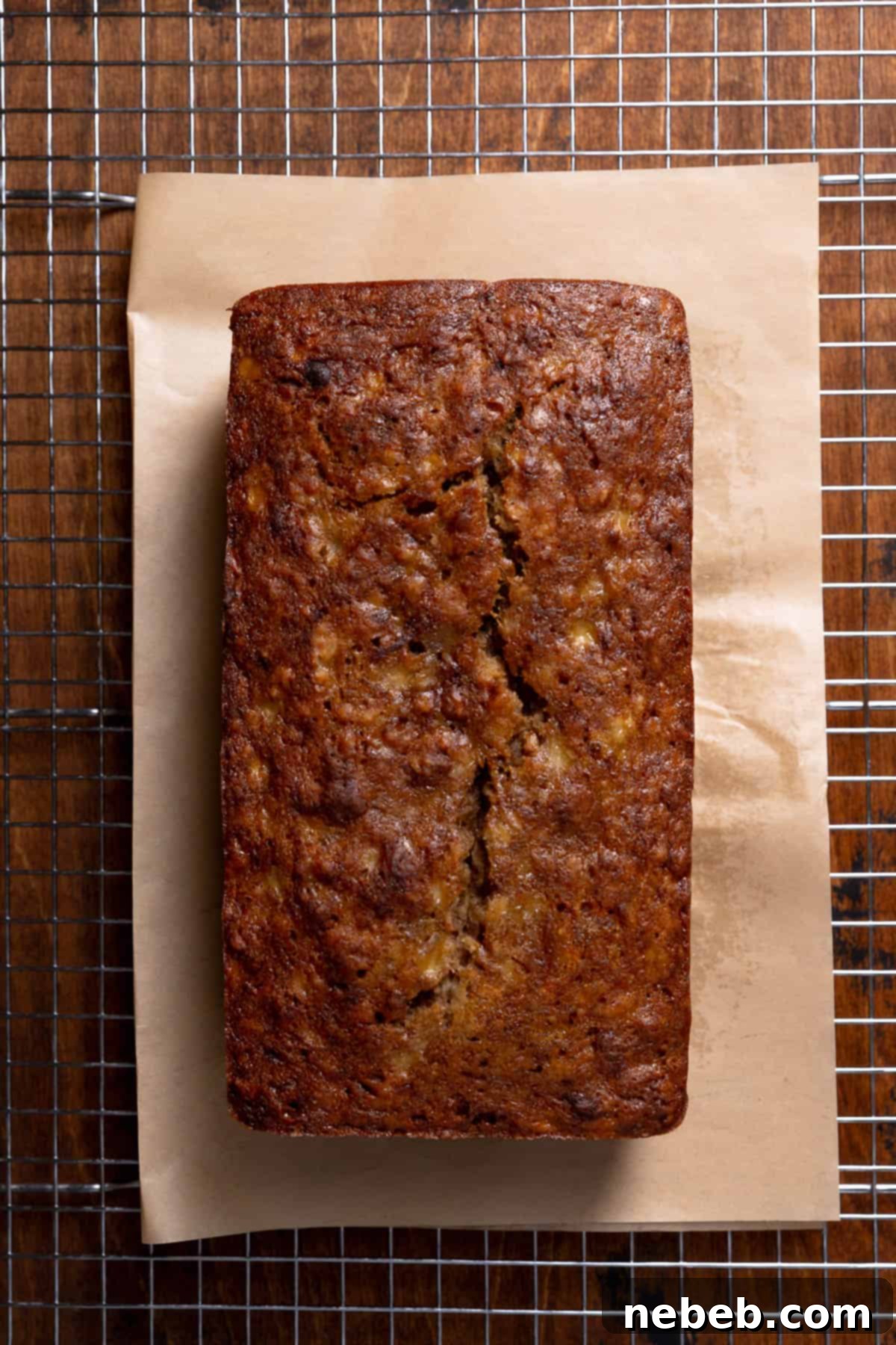 Baked banana bread cooling on a wire rack after being removed from the loaf pan.