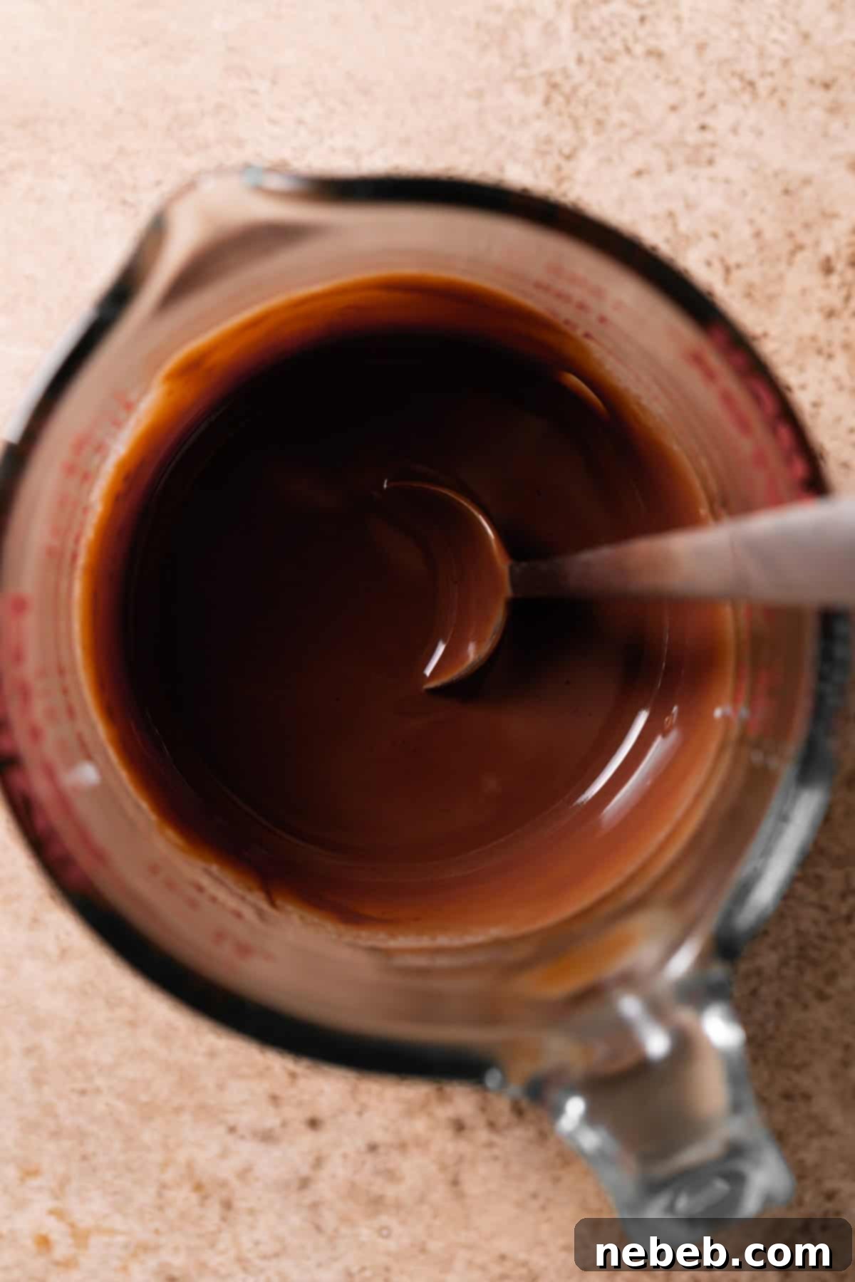 A mixing bowl with freshly made chocolate glaze, smooth and ready to be poured.