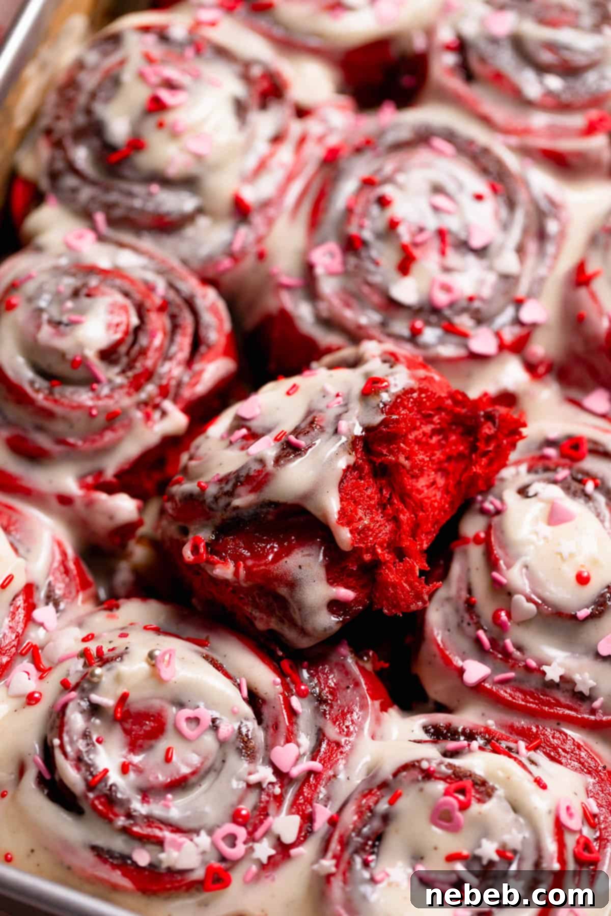 Red velvet cinnamon rolls in a baking pan.