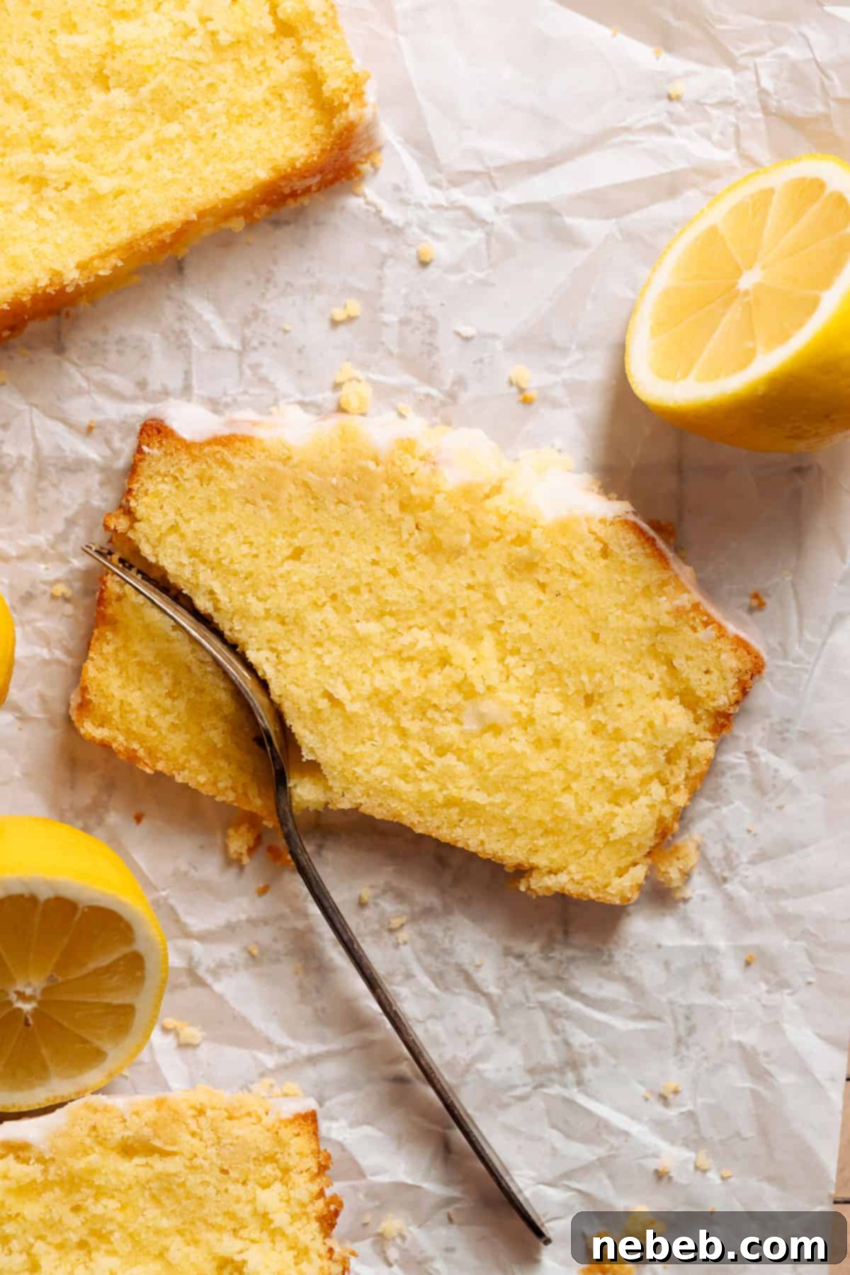A slice of lemon cake with a fork cutting into it.