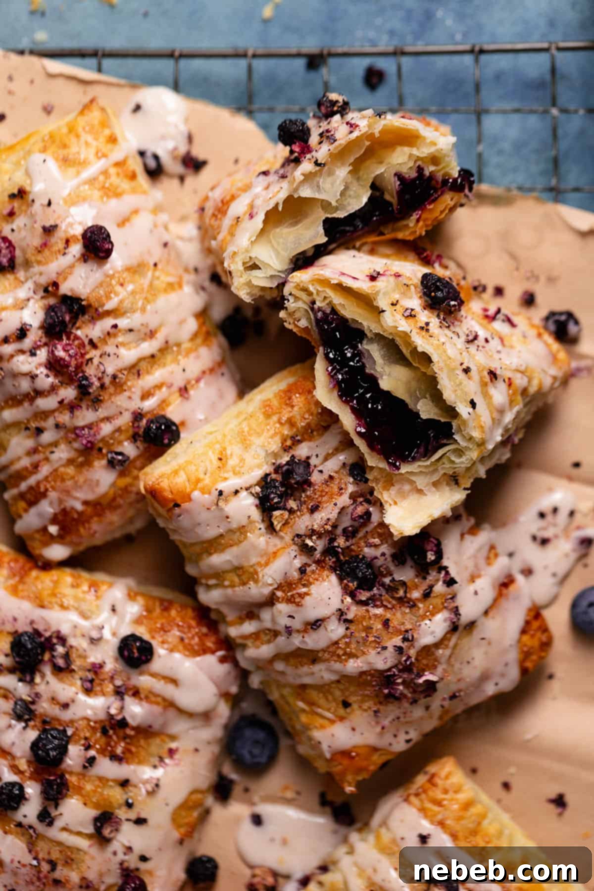Homemade toaster strudels with blueberry filling drizzled with vanilla icing, perfectly golden and inviting.