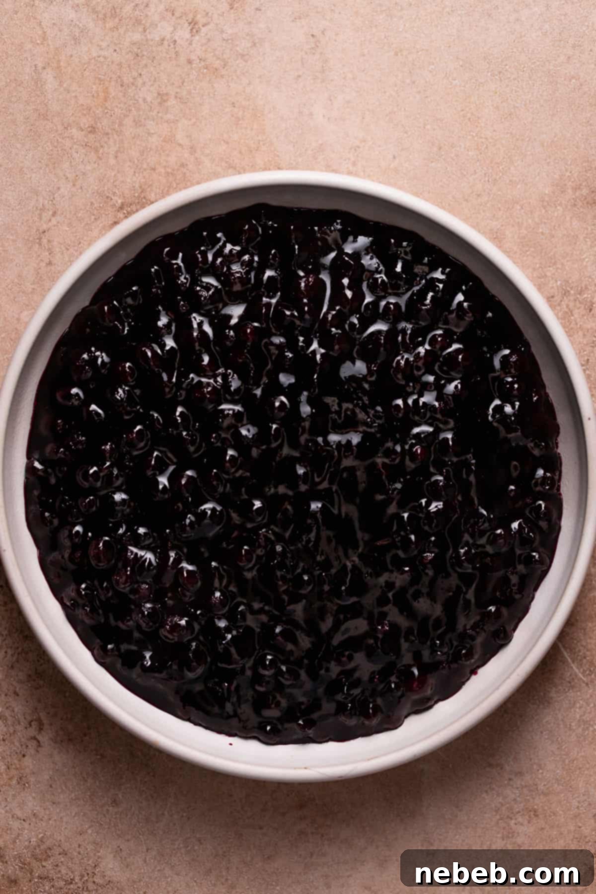 Blueberry jam cooling in a white bowl, showing its thick, rich texture.