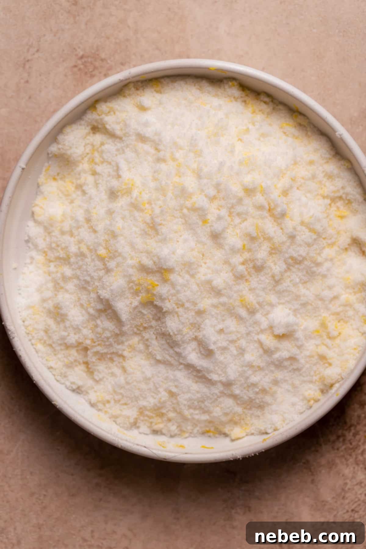 Zesty Lemon Raspberry Delight 4 Granulated sugar infused with lemon zest in a glass bowl, ready for baking.
