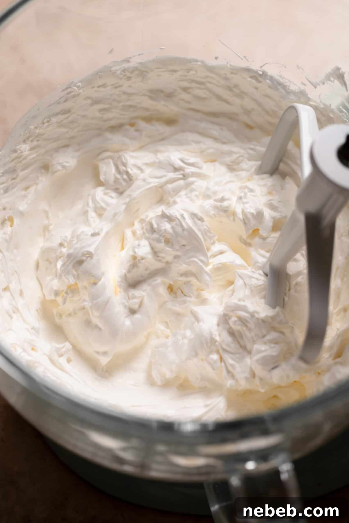 Zesty Lemon Raspberry Delight 9 A large bowl of perfectly whipped Swiss meringue buttercream, showcasing its light, fluffy, and smooth texture.