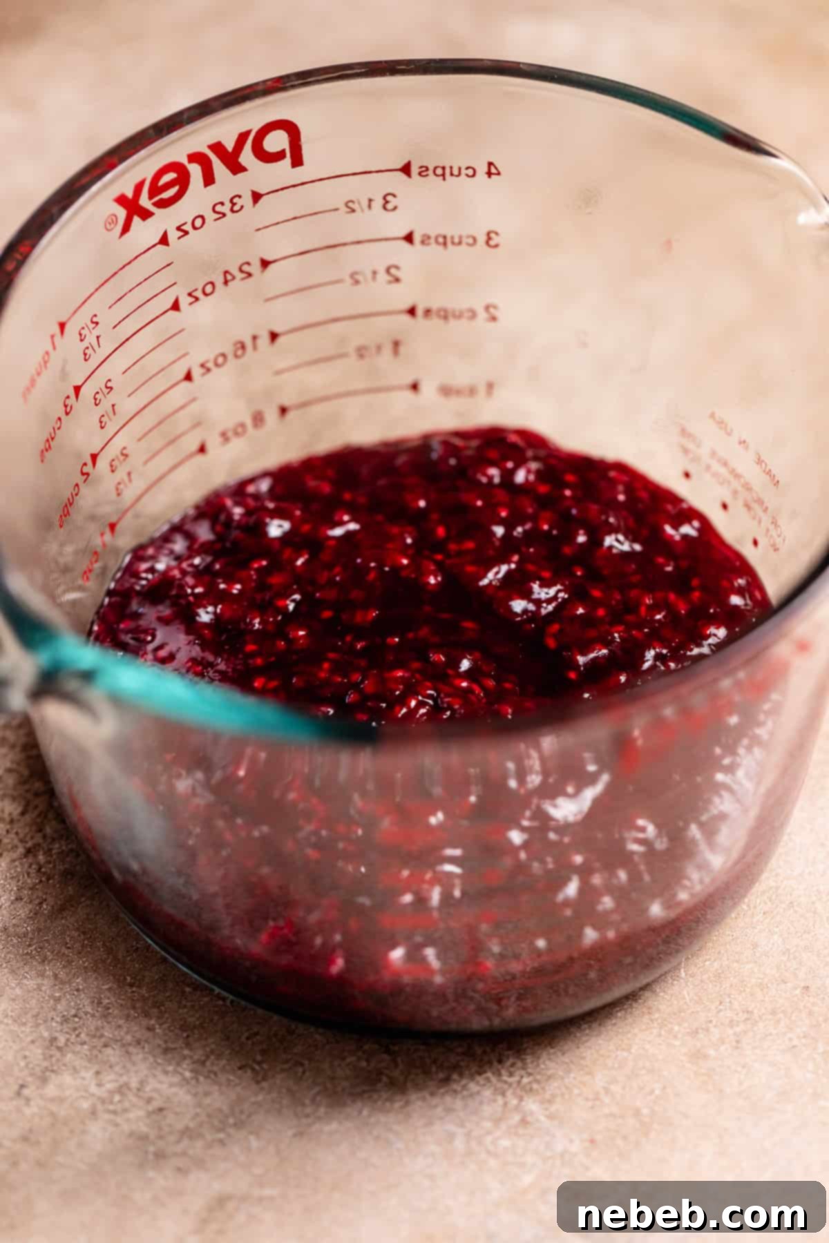 Homemade blackberry and raspberry jam in a glass bowl, showcasing its thick, rich texture.