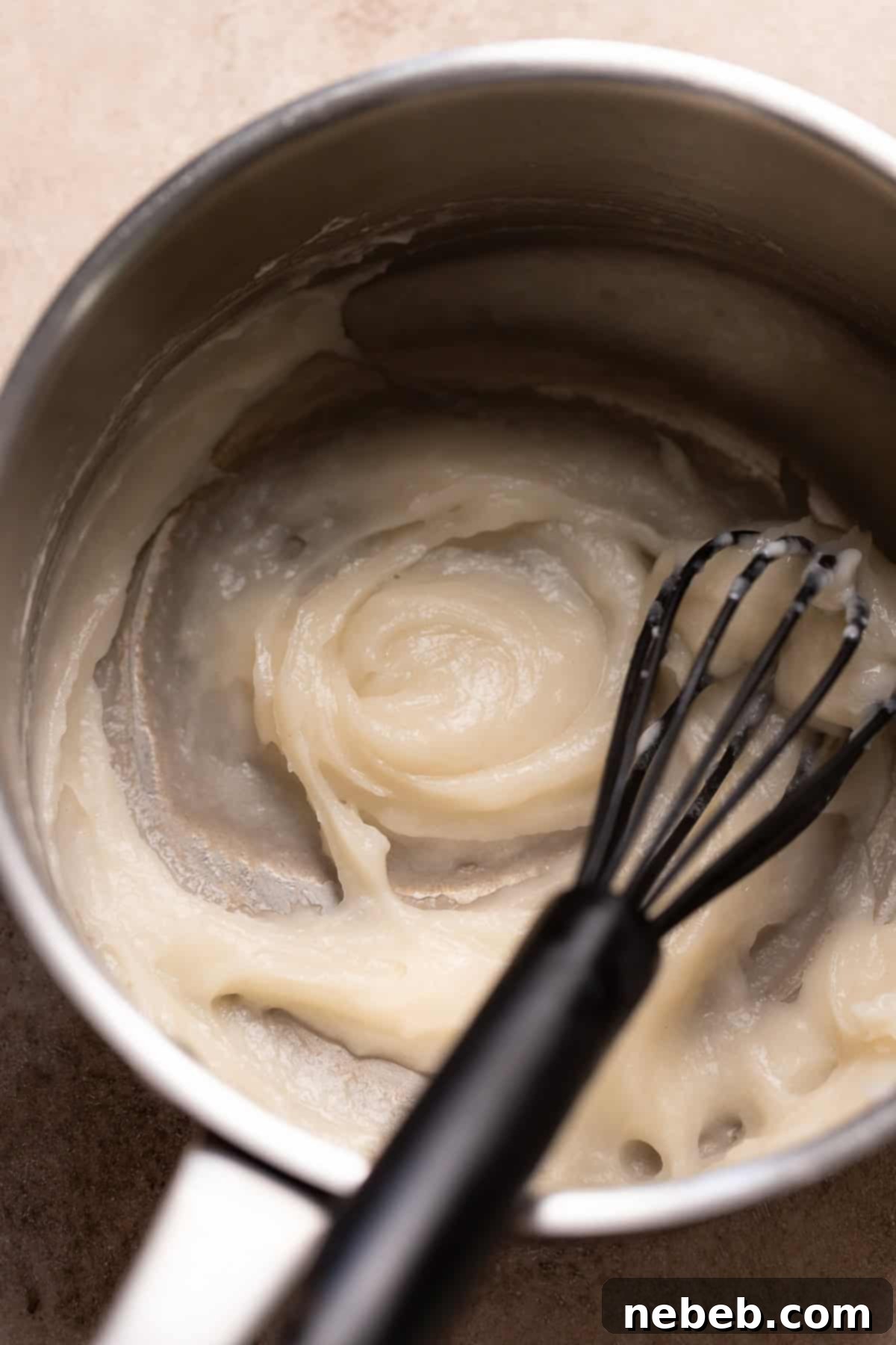 Tangzhong, a smooth, paste-like mixture, being whisked in a small pot.