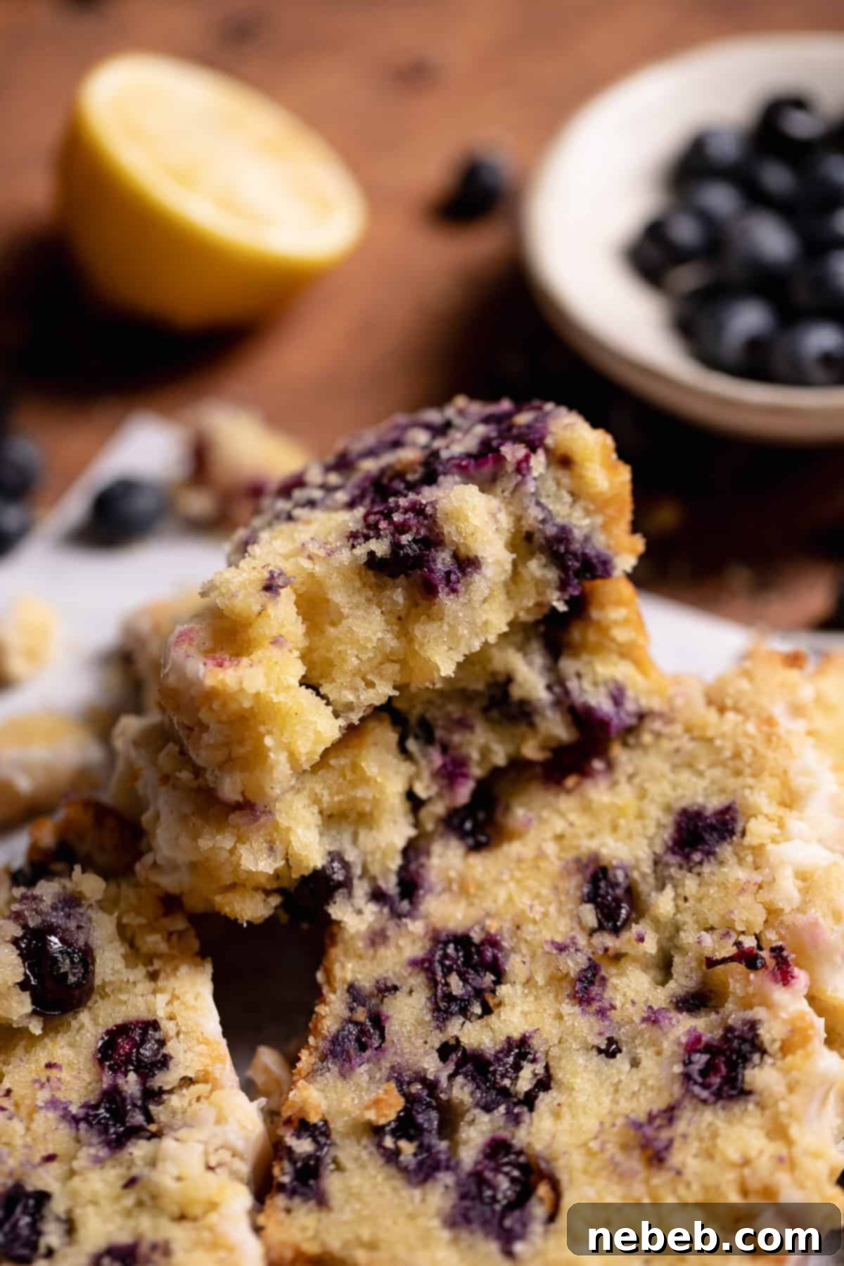 A slice of blueberry bread broken in half to show the moist texture.