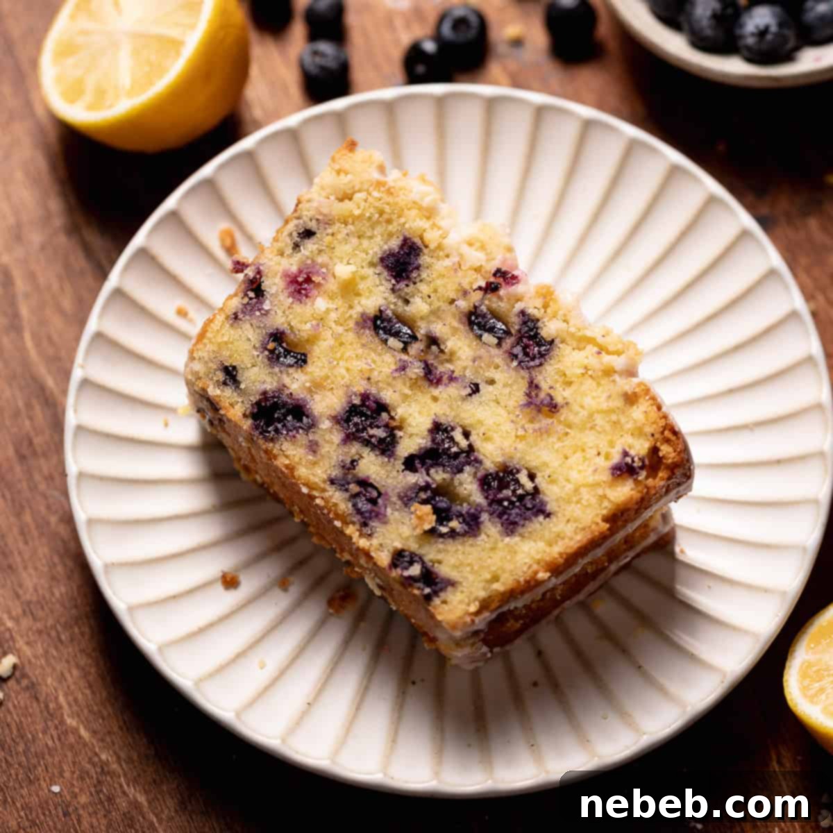 A slice of lemon blueberry cake on a white plate.