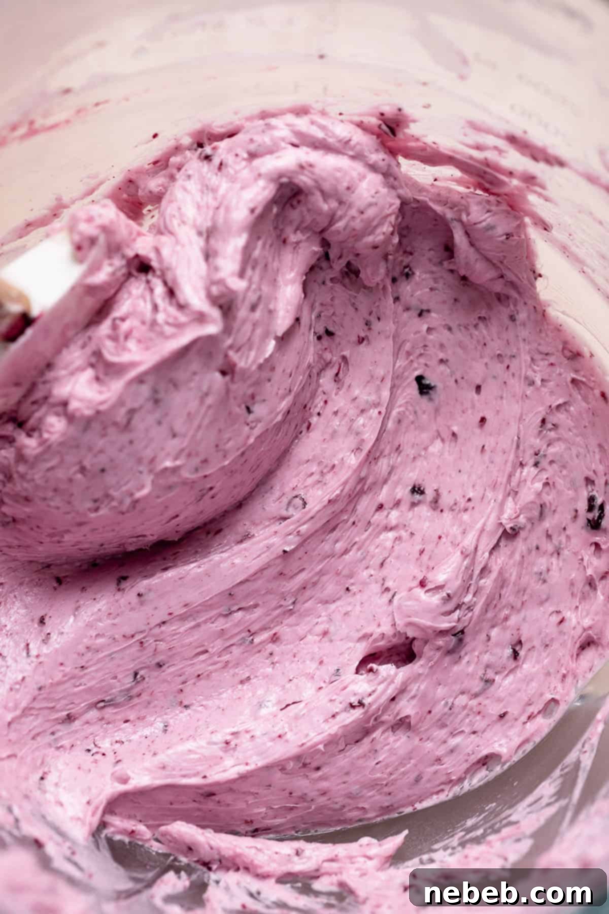 Blueberry frosting in a glass mixing bowl.