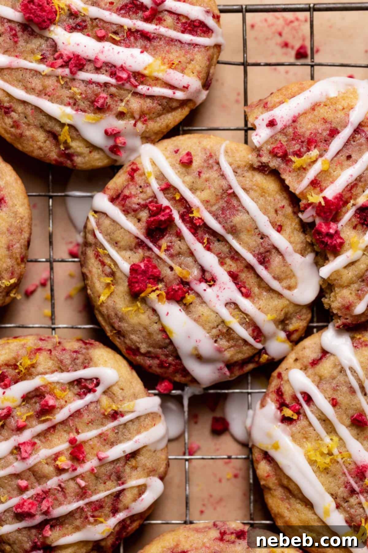 Lemon raspberry cookies with lemon icing and fresh lemon zest on top.