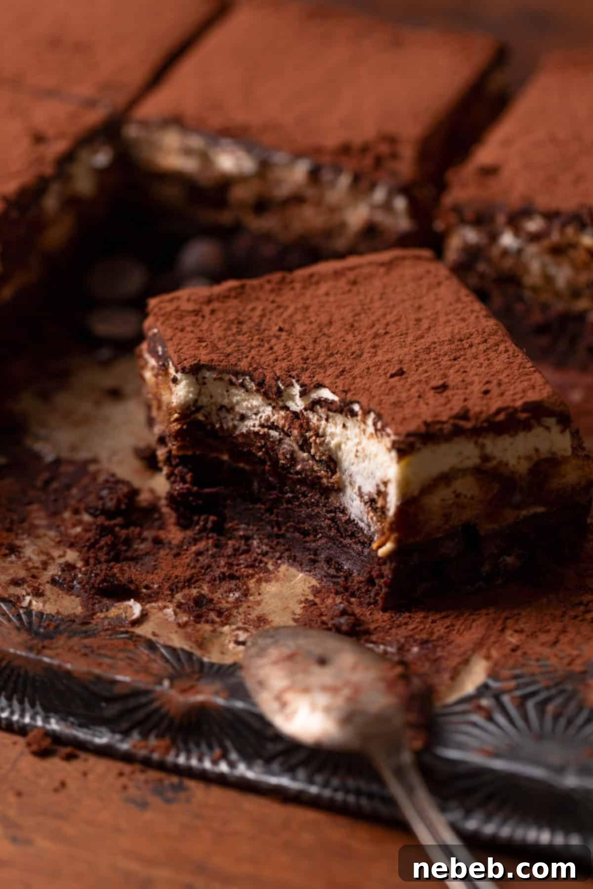 A fudgy tiramisu brownie with a bite taken out, showing its rich, dense texture and layered goodness.