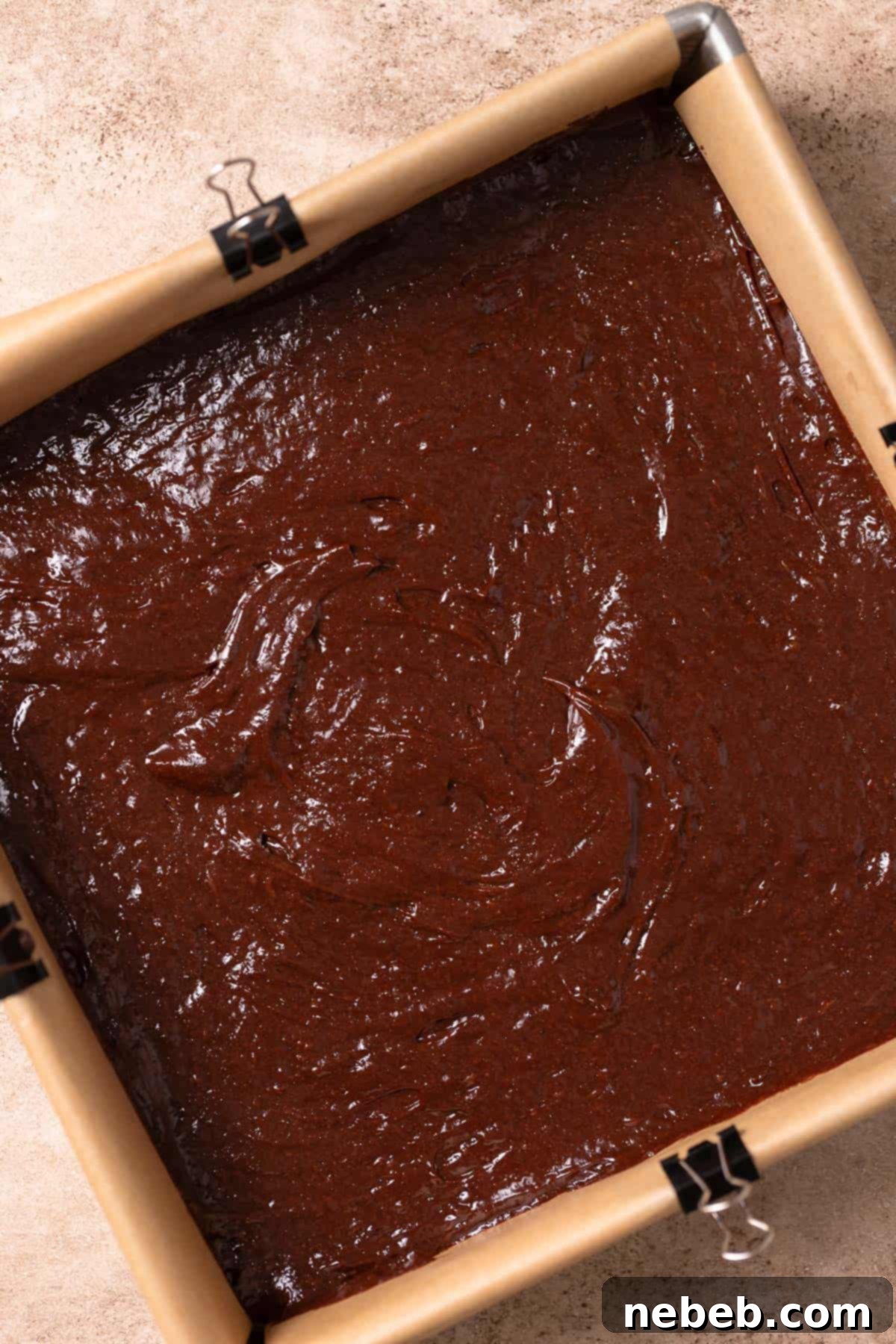 Brownie batter evenly spread in a baking pan, ready for baking.